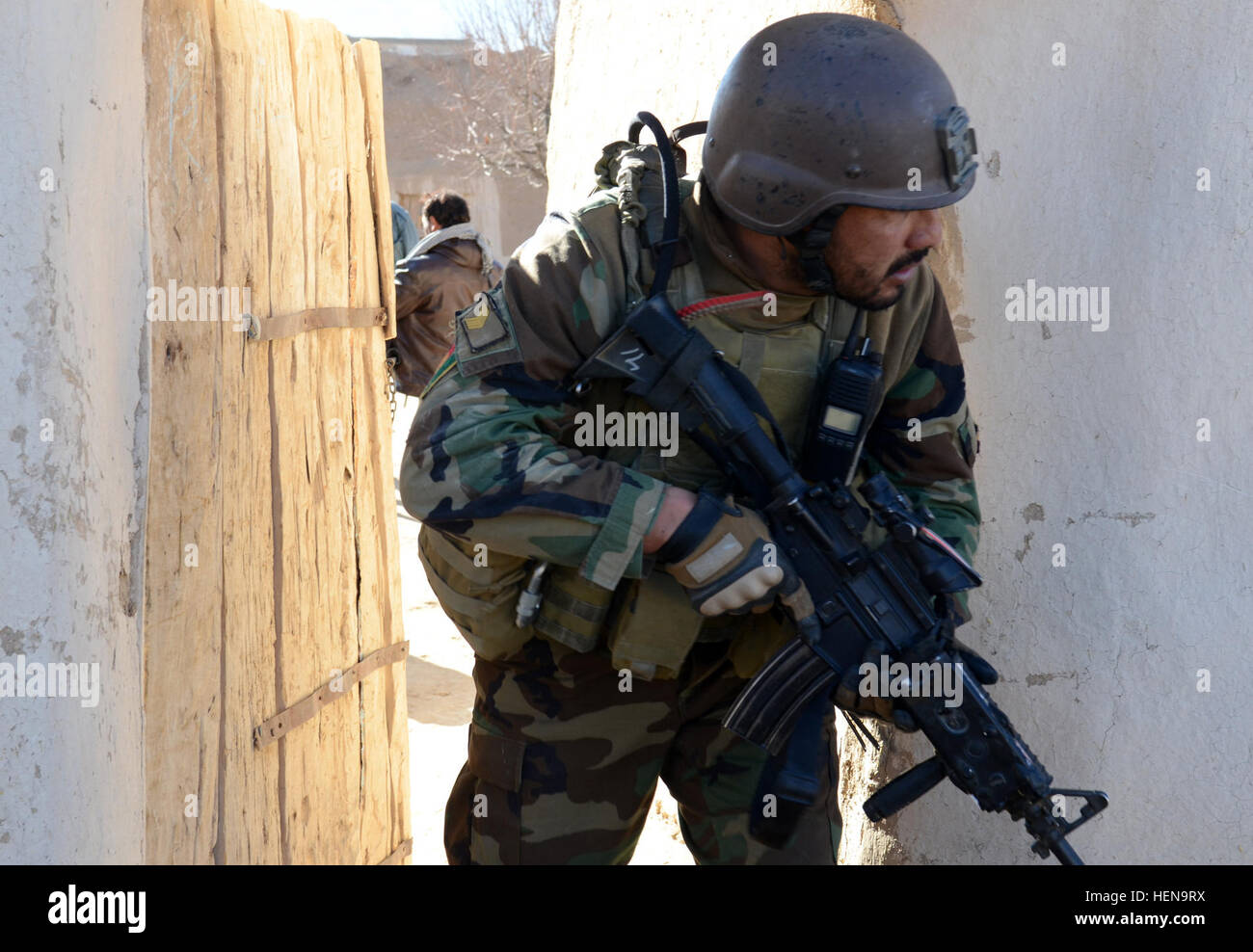 Ein Afghan National Army Special Forces Soldaten bewegt sich auf ein anderes Haus während einer Clearing-Operation in Mohammad Ghaws Dorf 16. Dezember 2013, im Ab Band District, Provinz Ghazni, Afghanistan. Die Sicherheitskräfte entdeckten viele improvisierte explosive Vorrichtungen und Waffen Caches während des Betriebs. Sie fanden mehrere Pfund hausgemachte Sprengstoff, Handgranaten, ca. 200 Schuss von AK-47 Angriff Gewehrmunition und medizinische Versorgung. (Foto: US-Armee Sgt. Jared Gehmann) ANASF, ALP reduzieren Waffen, explosive Caches 131216-A-ZR634-120 Stockfoto