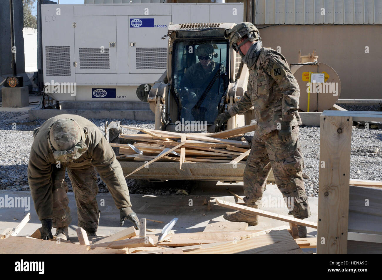 Mit Hilfe vom Fahrer ein Case Lader, Lansing, N.C. native, Spc. Anthony Greer, Spezialist für Zimmerei/Mauerwerk und Bland, Virginia stammende Spc. Jesse Deatley, Klempner, erholen beide mit dem 760. Engineer Company, 489th Engineer Battalion Holz von einer Dekonstruktion Projekt am Kandahar Flugplatz Jan. 11. Der Großteil der wiederverwendbaren Baustoffen aus dem Projekt wird wiederverwendet im Theater oder in der militärischen Lager für den Einsatz an anderer Stelle zurückgestellt werden. (Foto: US-Armee Sgt. 1. Klasse Jon Cupp, 82. SB-CMRE Public Affairs) 489th Pionier-Bataillon dekonstruiert aufbauend auf KAF 14011 Stockfoto