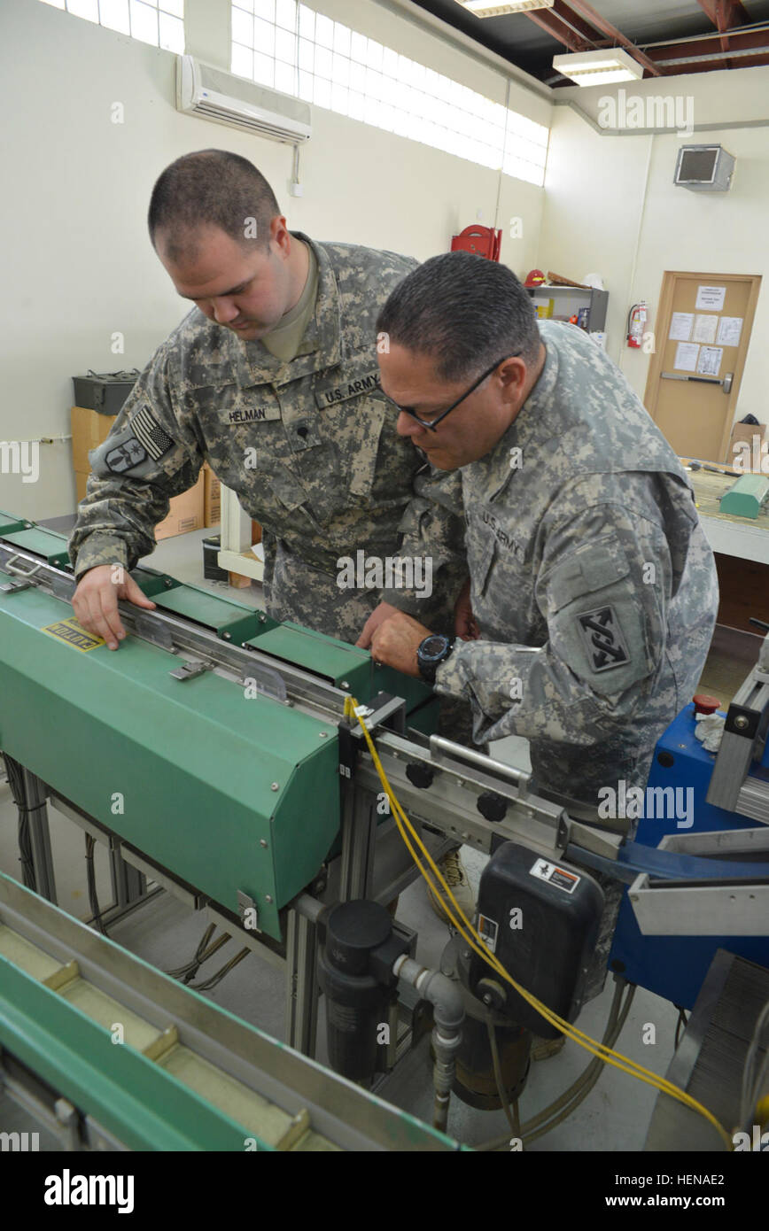 SPC. Zackary T. Helman (links), die Munition Lager Kontrolle und Buchhaltung Spezialisten der 371. Sustainment Brigade und Sgt. 1. Klasse Guillermo Matos (rechts), die Munition logistische Unteroffizier verantwortlich für den 143. Sustainment Befehl (Expeditionary), überprüfen Sie Schmutz und Ablagerungen in den ATACS im Camp Arifjan, Kuwait. Staubigen Klima des Landes macht die Maschine eingeklemmt Riemen, verstopfte Sensoren und schmutzige Objektive anfällig. Helman Aufgaben gehörte bläst die Maschine frei von Fremdkörpern. Dollar für Kugeln, Thalys-Arten Munition, spart Geld, stärkt Manpower 140114-A-DB40 Stockfoto