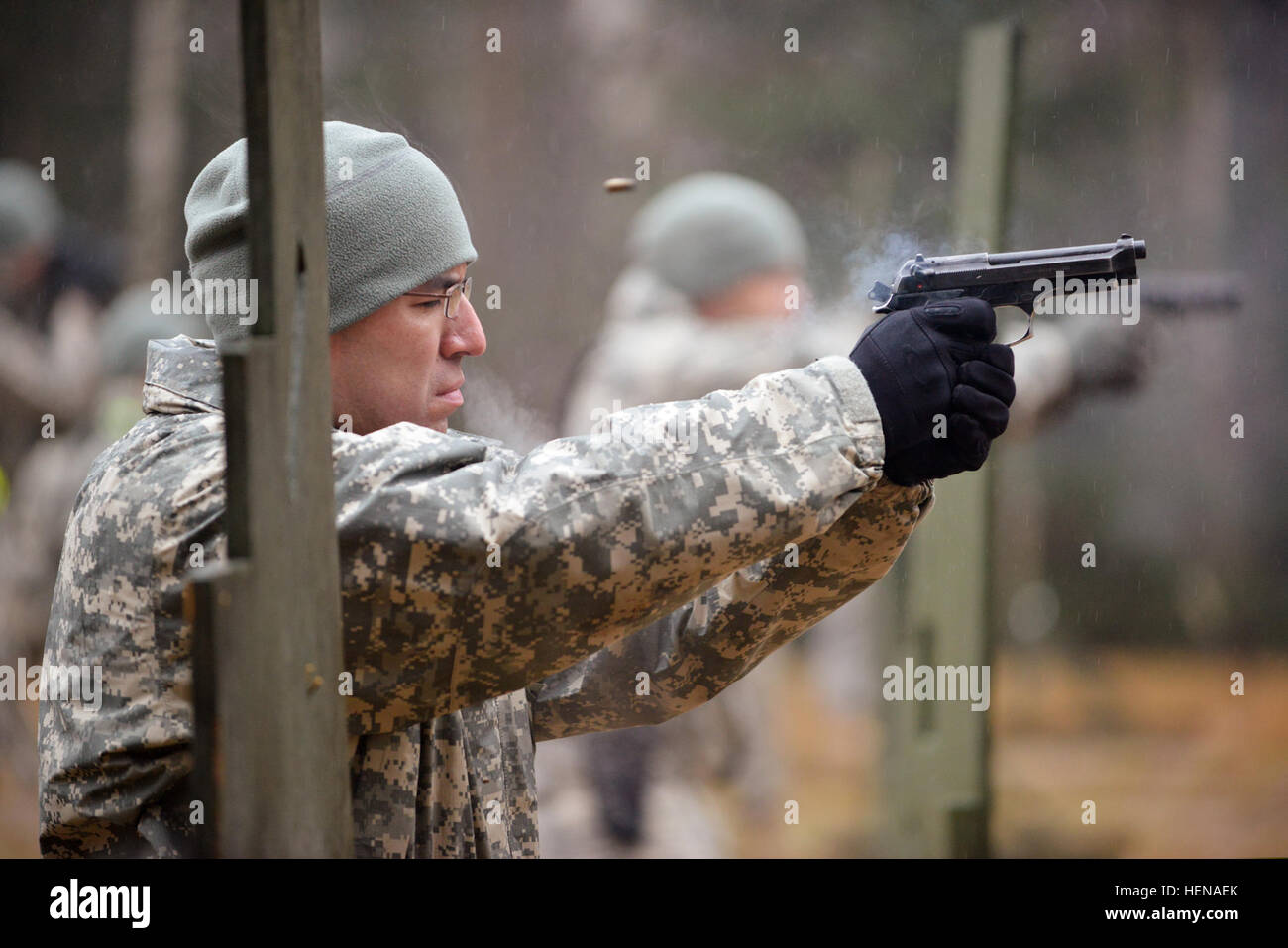 US Armee Sgt. 1. Klasse Jose J. Mejia, zugewiesen, 615th Militärpolizei (MP), 18. MP Brigade feuert eine M9 Pistole während Waffen-Qualifikation am 7. Armee gemeinsame multinationale Ausbildung des Befehls (JMTC) Grafenwöhr Training Area, in Deutschland, 13. Januar 2014.  (US Armee-Foto von Gertrud Zach/freigegeben) US Armee Sgt. 1. Klasse Jose J. Mejia, zugewiesen, 615th Militärpolizei (MP), 18. MP Brigade feuert eine M9 Pistole während Waffen Qualifikation bei der 7. Armee gemeinsame multinationale Ausbildung des Befehls (JMTC) 140113-A-HE359-015 Stockfoto