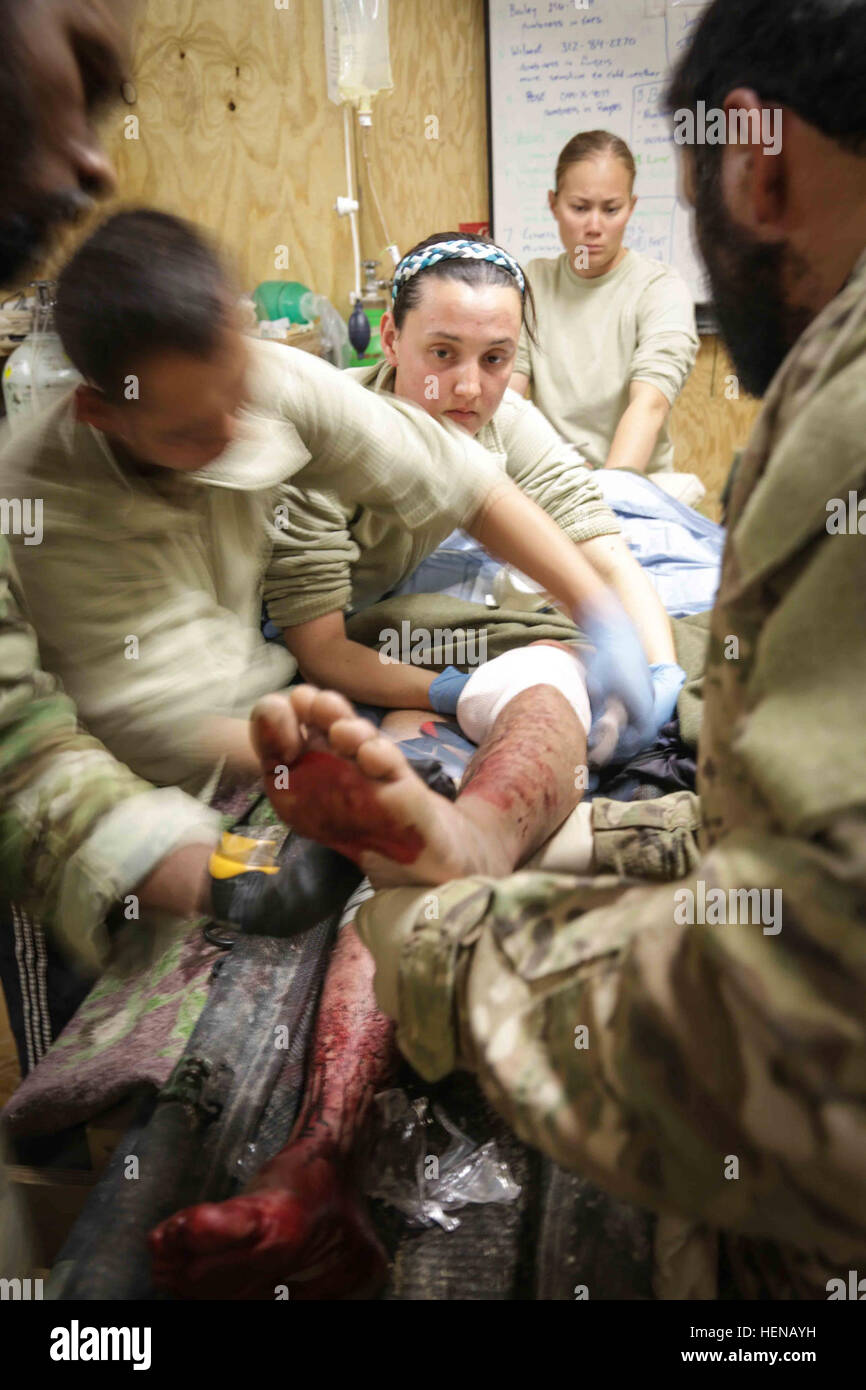 Eine afghanische Nationalarmee Medic, unterstützt von US-Militärangehörige, gilt Gaze für ein Afghan National Army Soldat verwundet in Shah Freude Bezirk Zabul Provinz, Afghanistan, 24. Januar 2014. Der Soldat erlitt Schussverletzungen auf beide Beine bei einem Feuergefecht mit Aufständischen im Distrikt Shah Freude. (Foto: U.S. Army Pfc David Devich / veröffentlicht) US-Militärangehörige und afghanische nationale Armeesoldaten bieten medizinischen Behandlung eines afghanischen nationalen Armee Soldaten verwundet in Shah Freude District, Provinz Zabul 140124-A-XP635-042 Stockfoto