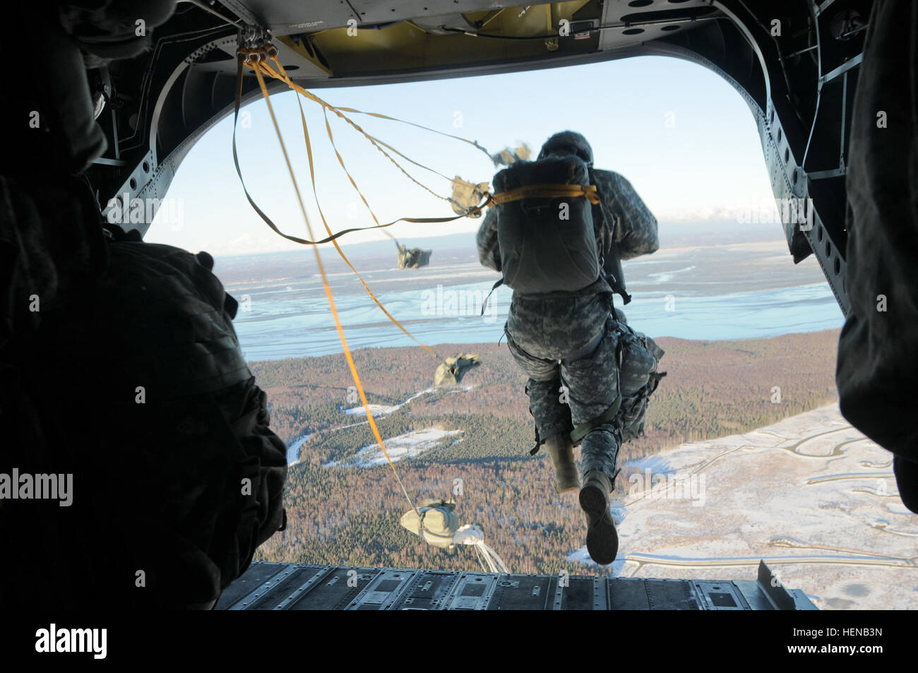 Ein Fallschirmjäger mit dem 1. Bataillon, 501. Infanterie-Regiment, 4th Infantry Brigade Combat Team (Airborne), 25. Infanterie-Division, springt aus einer Bravo Company, 1. Bataillon, 52. Aviation Battalion "Zucker-Bären" CH-47 Chinook-Hubschrauber wie es fliegt über die Drop-Zone 29. Januar 2014, bei gemeinsamen Basis Elmendorf-Richardson, Alaska. Die Fallschirmjäger das Flugzeug verlassen und stieg auf Malemute Drop-Zone für ihre Follow-on Mission zur Unterstützung der Spartan Brigade neuntägigen Feld Trainingsübung mit Schwerpunkt auf schnelle Bereitstellung, Eintrag und Folgenahrung Einreichung Expansion gezwungen. (US Armee-Foto von Stockfoto