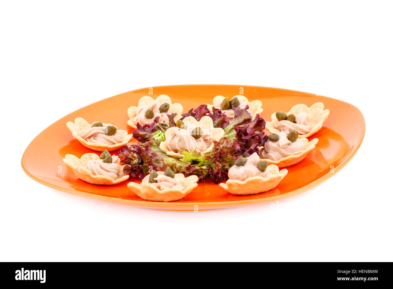 Fisch, Sahne und Kapern in Gebäck, Salat auf Teller. Stockfoto