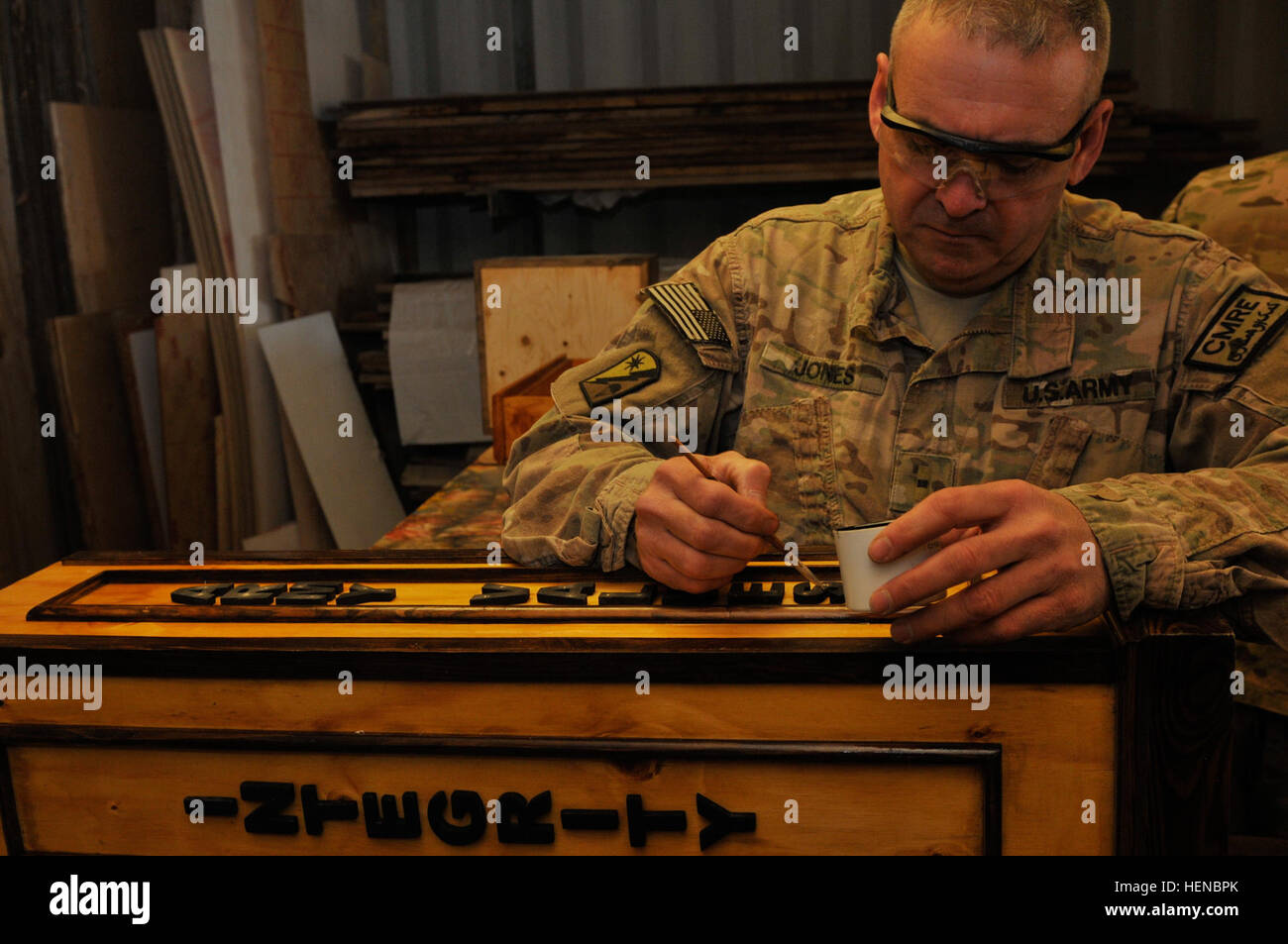 US Army Warrant Officer Randy Jones, Offizier verantwortlich für die 489th Pionierbataillon Holzgeschäft, arbeitet mit schwarzer Farbe zum Abschließen eines Projekts in der Werkstatt am Kandahar Flugplatz, Provinz Kandahar, Afghanistan, 26. Februar 2014.  (US Armee-Foto von Spc. Aaron Ellerman/freigegeben) US Army Warrant Officer Randy Jones, der Offizier verantwortlich für die 489th Pionierbataillon Holzgeschäft, arbeitet an einem Projekt in der Werkstatt am Kandahar Flugplatz, Provinz Kandahar, Afghanistan 140226-A-AP268-091 Stockfoto