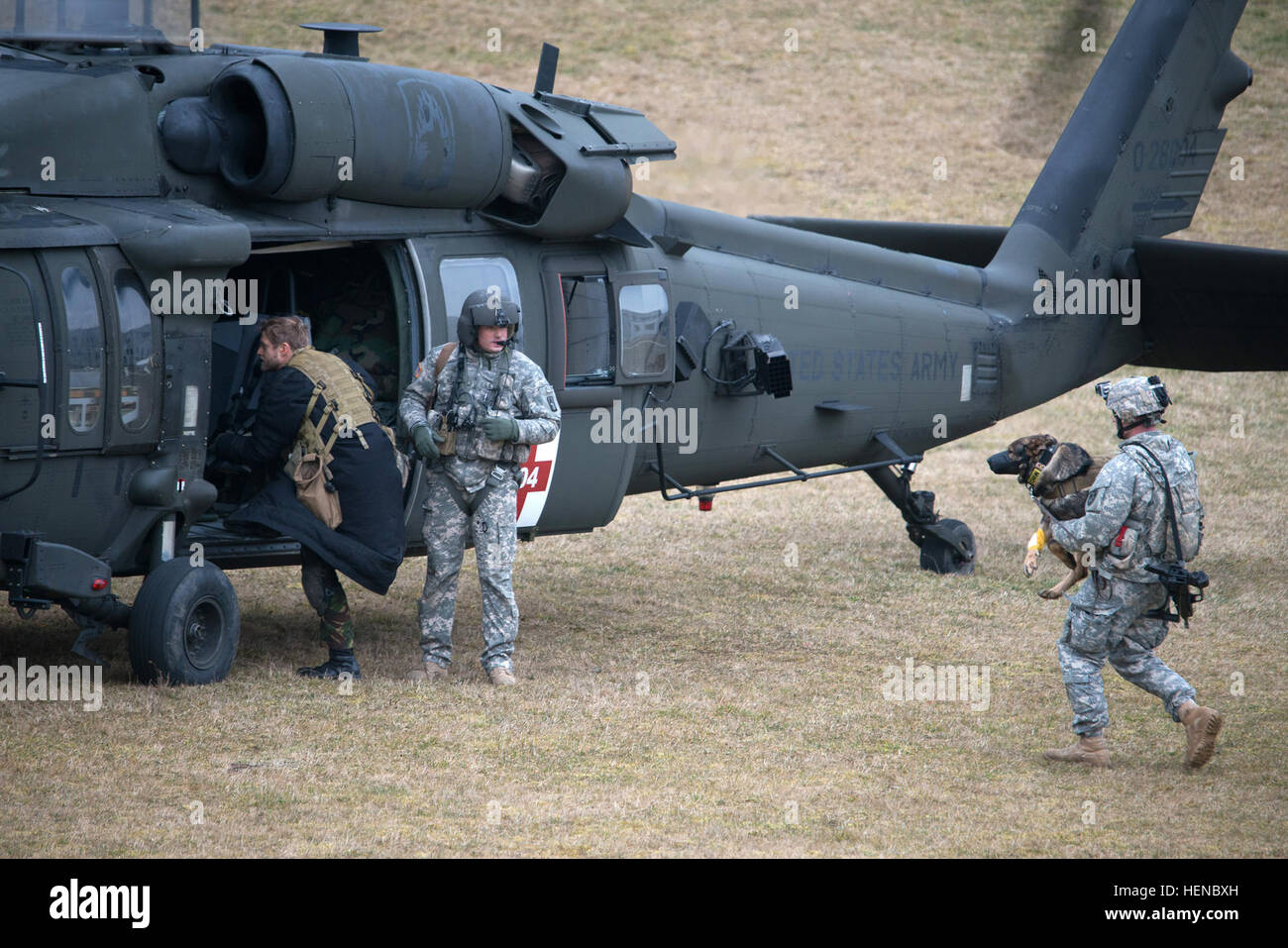 Ein Uh 60 Black Hawk Hubschrauber Aus 5 Bataillon 158 Aviation Regiment Mit Simulationspatienten Geladen Ist Eine Rolle Mit Einer Wunde Klettert An Bord Wie Ein Hundefuhrer Tragt Seine Gebrauchshund Mit Simulierten Gebrochenen Bein