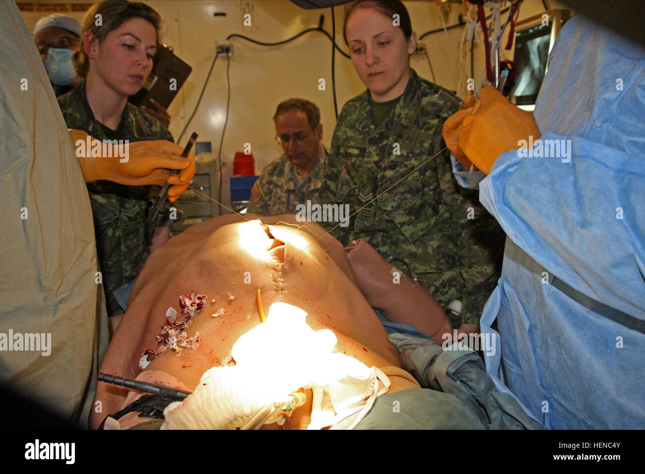 Zwei kanadische Soldaten 1 Field Ambulance, Edmonton, Alberta, Uhr Ärzte Naht die Brust eines Human-Worn teilweise Aufgabe chirurgische Simulators, betitelt dem "cut Anzug," getragen von einem Soldaten während der 78th Training Abteilung Combat Support Training Übung/Global Medic 78-14-01 22. Februar 2014, bei Joint Base McGuire-Dix-Lakehurst, N.J. (Foto mit freundlicher Genehmigung von MRTC) medizinische Ausbildung wird realistischer 140222-A-ZZ999-004 Stockfoto