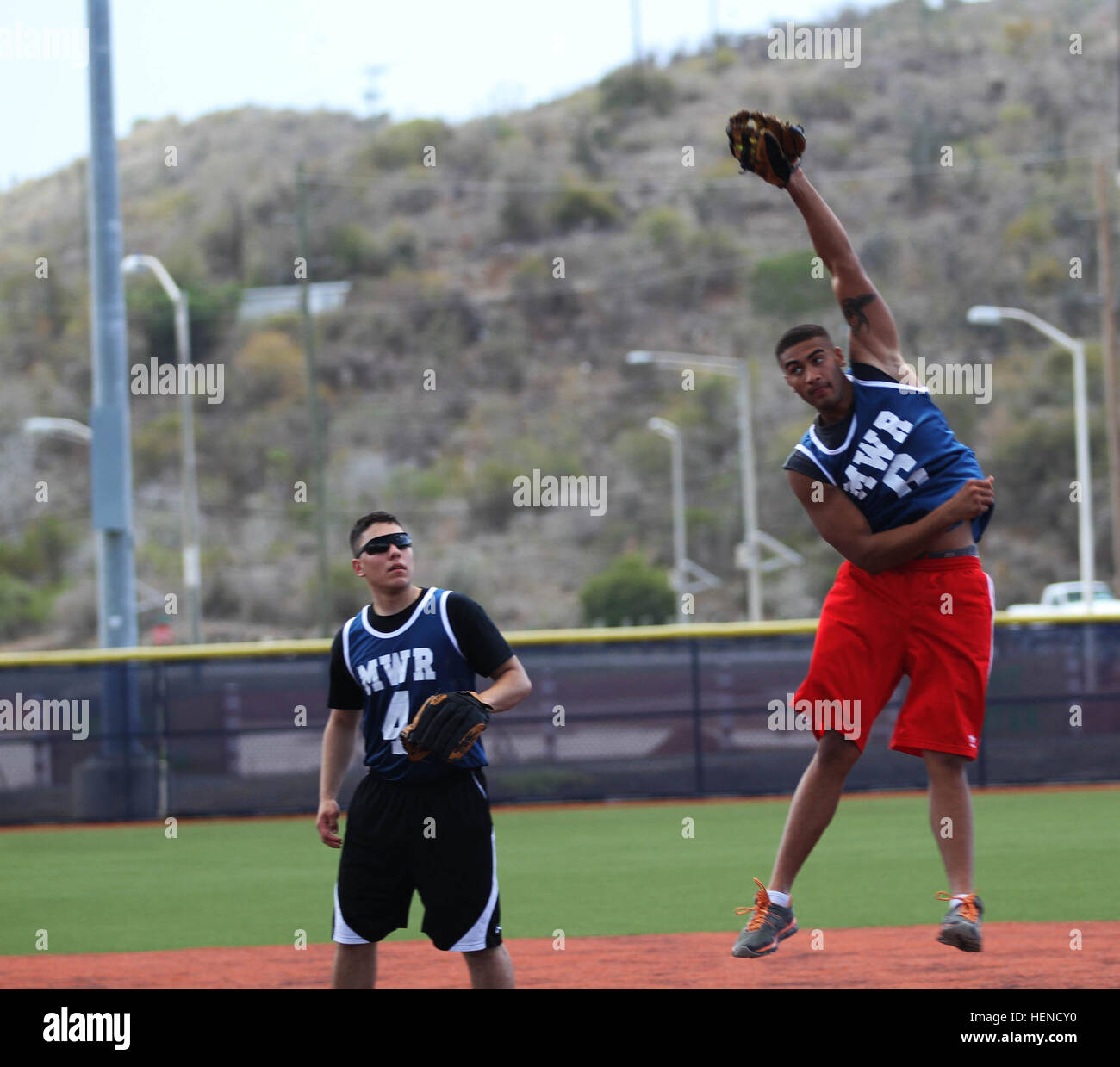 Ein Soldat mit Joint Task Force Guantanamo springt um eine Pop-Fliege während der St. Patricks Tag Softball-Turnier am Naval Station Guantanamo, Samstag, 15. März nab. JTF-Soldaten halten Glück o %%% E2 %%% 80 %%% 99 die Iren im Softball Turnier 140315-A-PO157-940 Stockfoto