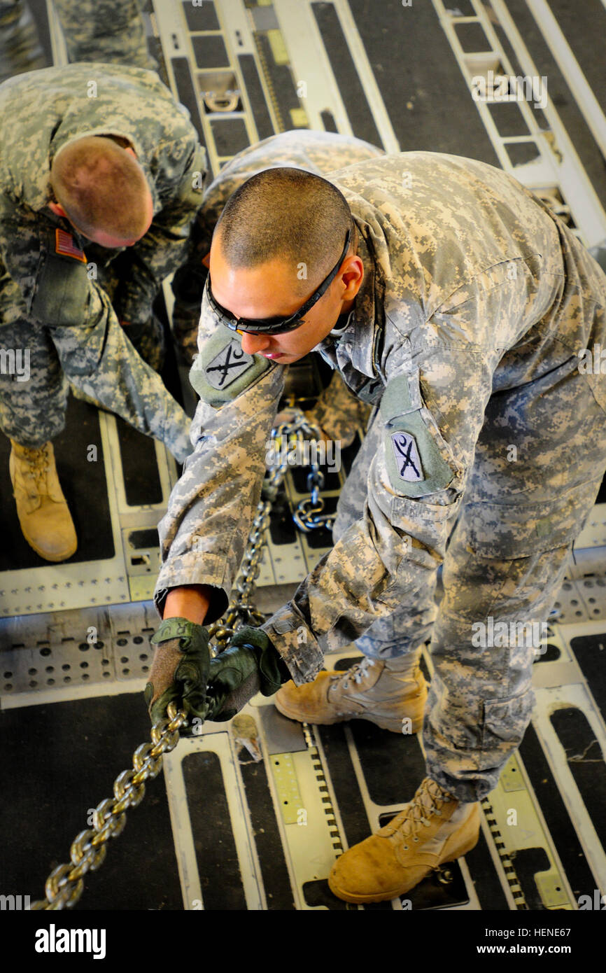 US Armee Sgt. Rudy Uribe, M1 Rüstung Crewman, sichert eine M1A1SA Abrams mit schweren Ketten an Bord einer c-17 vor in die Flucht. Der South Carolina Army National Guard 1-118. Combined Arms Bataillons (CAB) beteiligt sich an schwere Luftbrücke Operationen 10. / 11. April 2014 bei Wright Army Flugplatz (WAAF), Hinesville, Ga., um die gemeinsame, totale Kraft, Fähigkeiten des S.C. Army Guard und US Air Force Reserve 315th Luftbrücke Flügel zu demonstrieren. Soldaten und Piloten arbeitete unisono über zwei Tage um zu laden und sichern vier 1-118. CAB neue M1A1SA Abrams Kampfpanzer auf vier US Luftwaffe c-17 tr Stockfoto