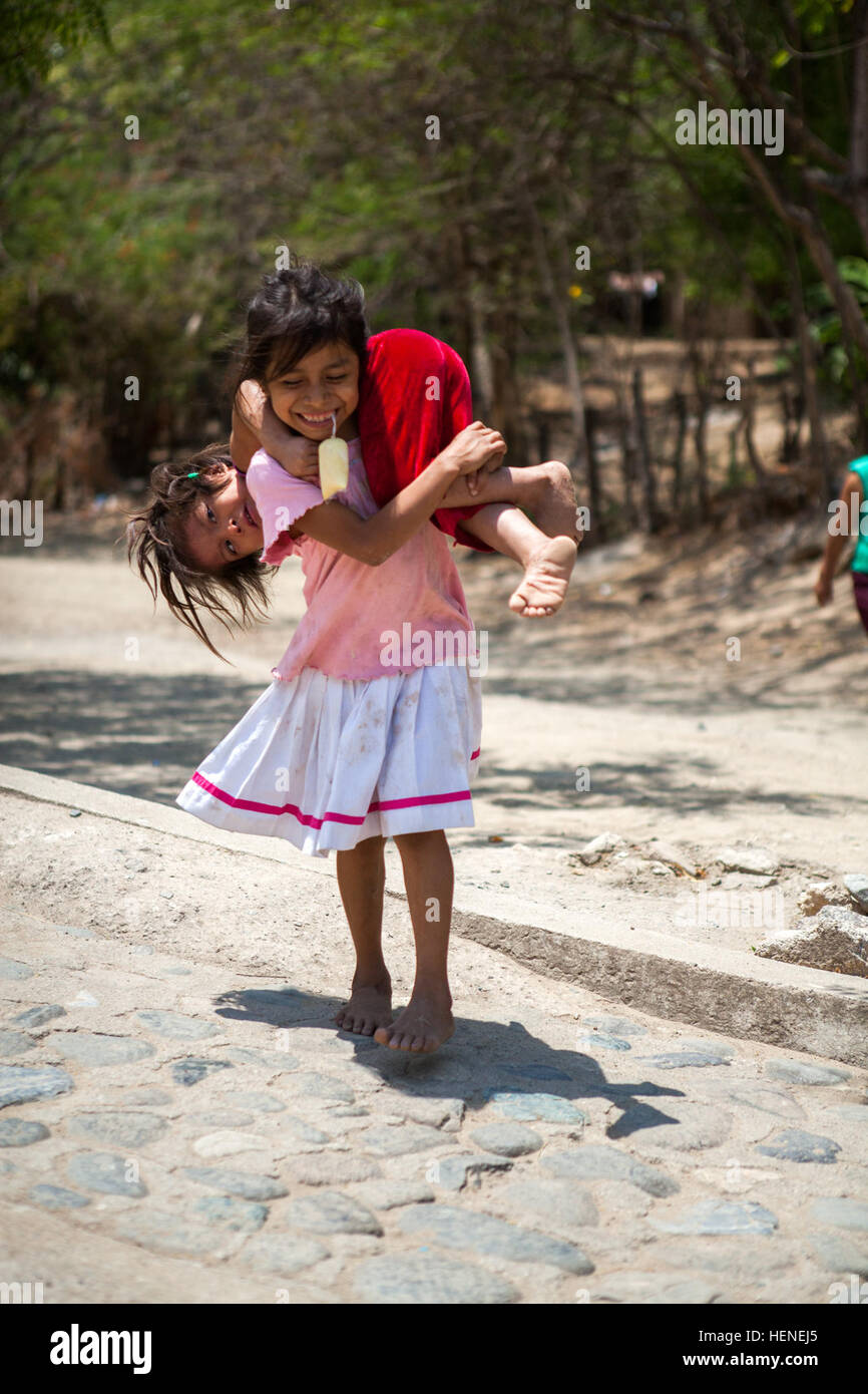 Ein junges Mädchen guatemaltekischen trägt ihre Schwester über die Schulter während Beyond the Horizon 2014, Zacapa, Guatemala, 16. April 2014. Hinter dem Horizont ist eine jährliche Übung, die die Partnerschaft zwischen den USA und Guatemala umfasst, bieten konzentriert humanitären Hilfe durch verschiedene ärztliche, zahnärztliche und bürgerlichen Action-Programme. (Foto: U.S. Army Staff Sgt Justin P. Morelli / veröffentlicht) Über den Horizont 2014, Guatemala 140416-A-PP104-133 Stockfoto