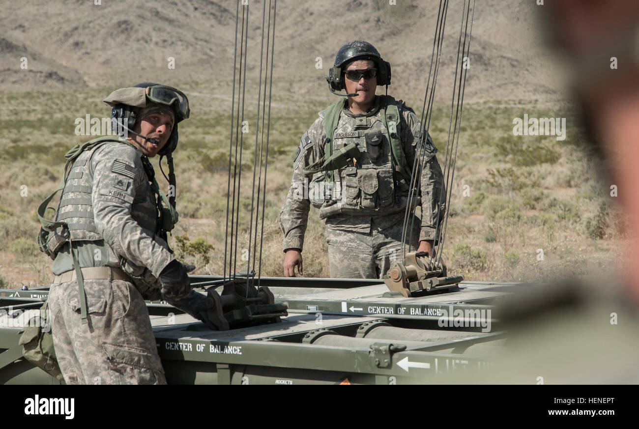 FORT IRWIN, Kalifornien - Soldaten der US Army, zugewiesene Alpha Company, 2. Bataillon, 1. Infanterie-Division, 34. Rüstung direkt Fellow Soldat während der Nachladen Verfahren auf einem m270 Multiple Launch Rocket System (MLRS) vor dem Start im National Training Center, 20. April 2014. Die MLRS ist ein Vielfaches gepanzerte, selbstfahrende, Raketenwerfer, die verwendet wird, um feindliche Ziele mehr als 175 Meilen entfernt zu engagieren und von feindlichen Zähler Feuer rasch an verschiedene Orte.  (Foto: US-Armee Sgt. Richard W. Jones Jr., Operations Group, National Training Center) M270 Multiple Launch Rocket System trai Stockfoto