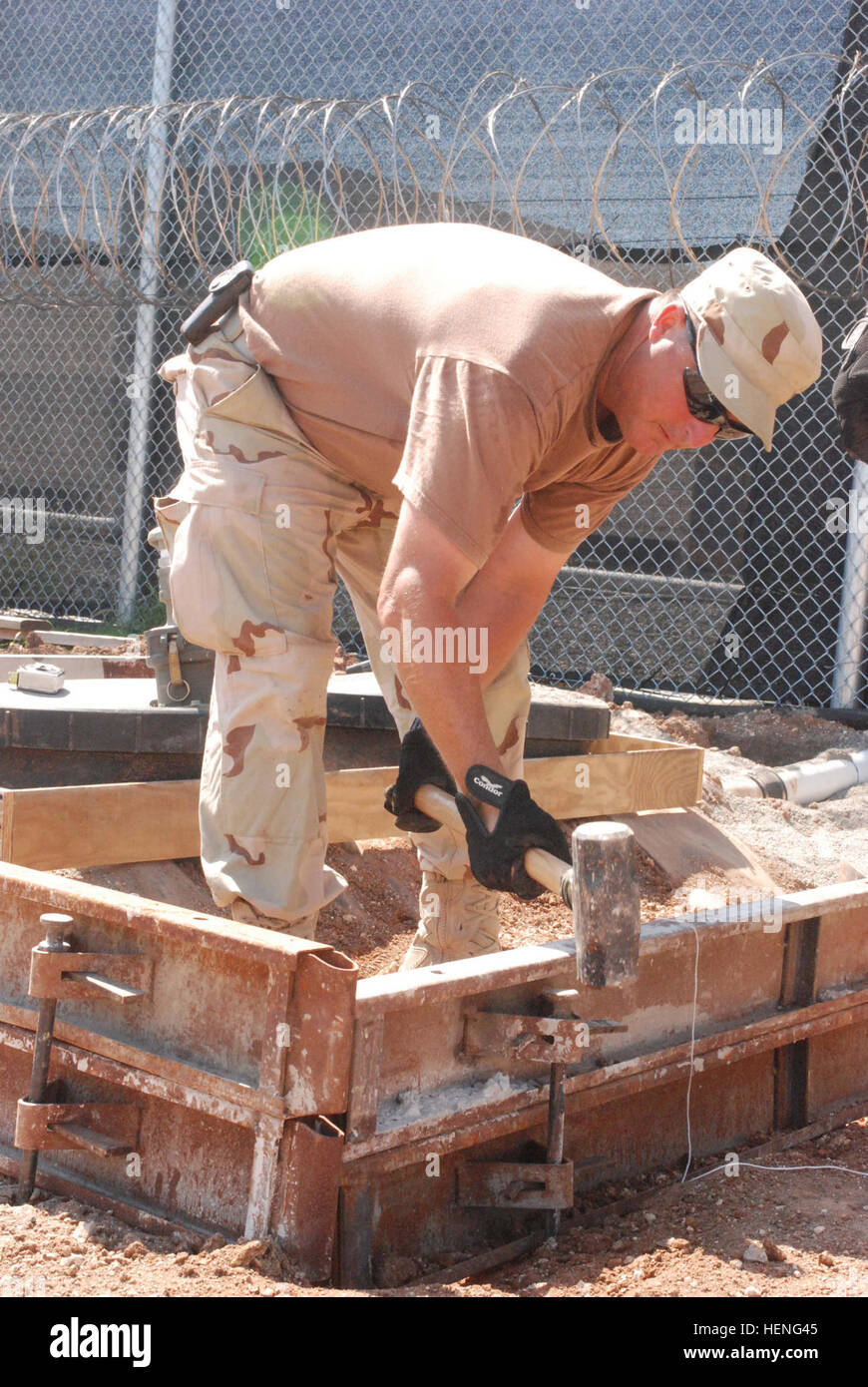 GUANTANAMO BAY auf Kuba – Air Force Staff Sgt Mike Hartman Hämmer Formen im Ort für ein Betonfundament im Camp Justice, 13. März 2008. Hartman ist Mitglied der 474th Expeditionary Tiefbau Geschwader, das Boden hier am 11. September 2007, brach, Expeditionary rechtlichen Komplex zu konstruieren. JTF Guantanamo führt durch sichere und humane Pflege und Obhut von Festgenommenen feindlichen Kämpfern. Die JTF führt Verhör Operationen um strategische Intelligenz zur Unterstützung der globalen Krieg gegen den Terror zu sammeln und Law Enforcement und Kriegsverbrechen Untersuchungen unterstützt. JTF Guantanamo engagiert sich für die Stockfoto