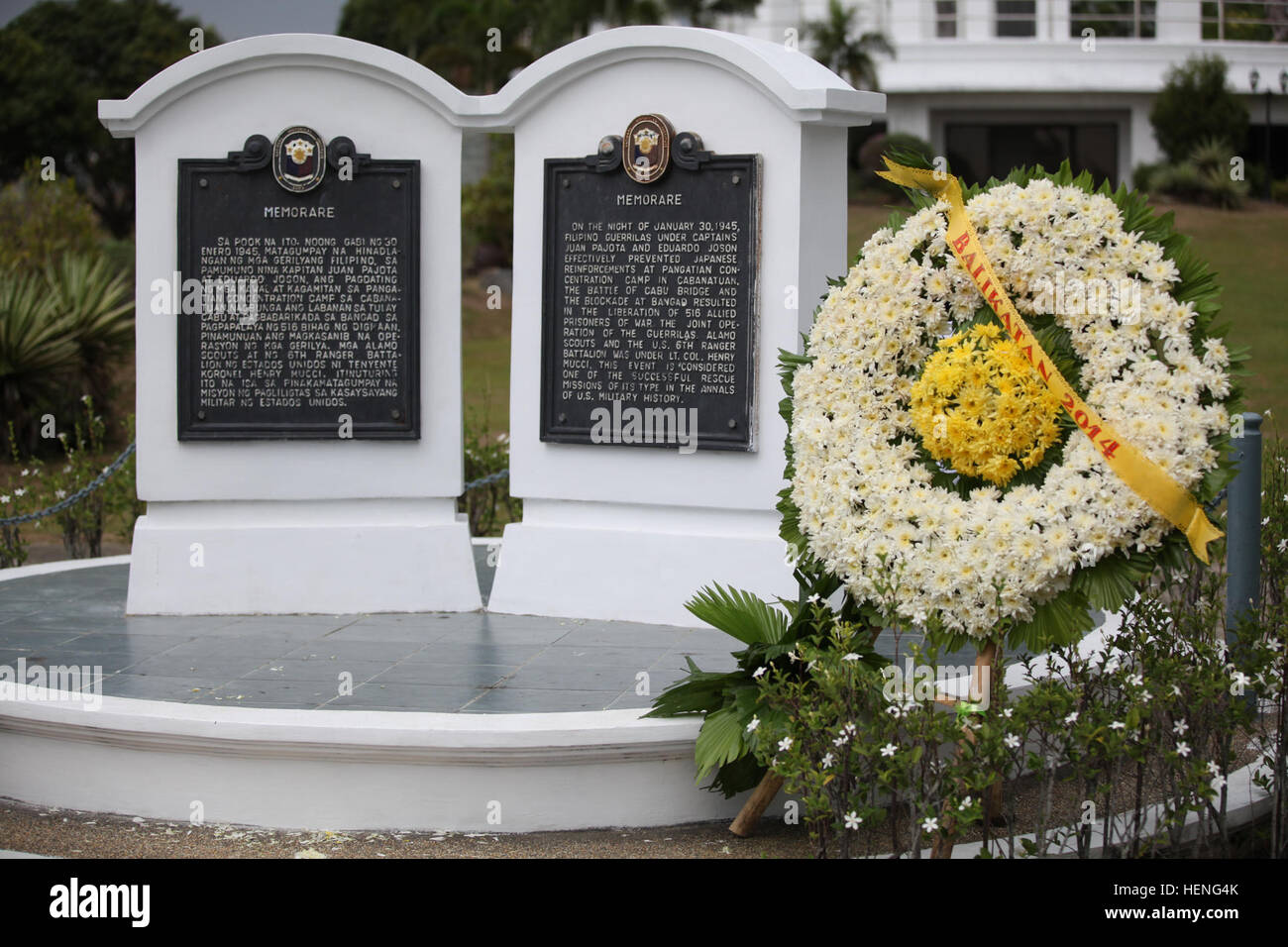 Ein Kranz von philippinischen gelegt und US-Armeesoldaten an der Pangatian Krieg Kranz Verlegung Gedenkfeier am Cabanatuan City, Philippinen Balikatan 2014, 10. Mai 2014.  Die Tabletten, geschrieben in Tagalog, links, und Englisch, Recht, erzählen von der Nacht philippinischen Armee Kapitän Juan Pajota und seine Männer verteidigt gegen die Japaner und unterstützt die US-Streitkräfte 516 Kriegsgefangene zu befreien.  Dieses Jahr markiert die 30. Iteration der Übung, die eine jährliche Republik der Philippinen und den USA militärische Trainingsübung bilateralen und humanitäre Hilfe Bürgerschaftliches Engagement ist.  (US Armee-Foto von Stockfoto