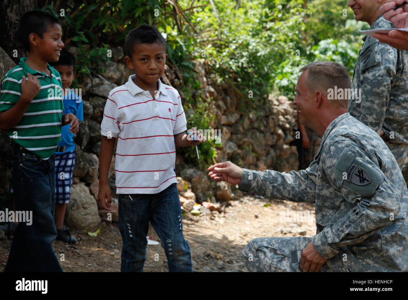 US Army Captain Gerald Walling DESUNTERNEHMENS 318th psychologische Operationen, Aktien Bonbons mit guatemaltekischen Kinder beim Führen einer Post-Assessment-Questionnaire nach einer medizinischen Bereitschaft Übung während Beyond the Horizon, Lomas Abajo, Guatemala, 28. Mai 2015. Hinter dem Horizont ist eine jährliche Übung, die die Partnerschaft zwischen den USA und Guatemala umfasst, bieten konzentriert humanitären Hilfe durch verschiedene ärztliche, zahnärztliche und bürgerlichen Action-Programme. (US Armee-Foto von Pfc. Christopher Martin/freigegeben) Über den Horizont 2014, Guatemala 140528-A-GA303-023 Stockfoto