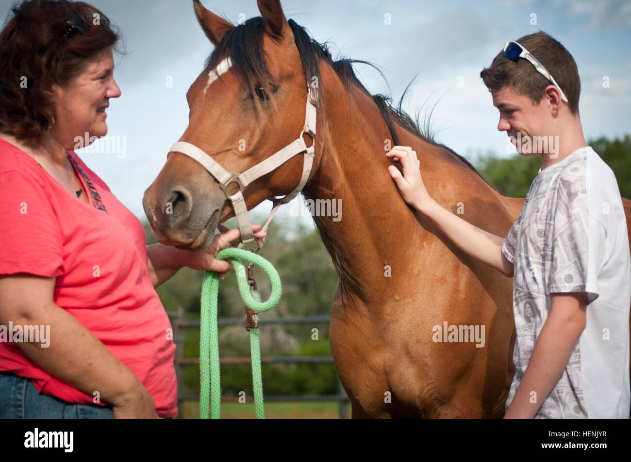 Donna Otabachian, executive Director der Star Heilung mit Pferde Ranch, führt eine Pferdetherapie-Sitzung mit Roger Flores-Hoops, 14, 17. Juni 2014 sekundäre PTBS leidet. SHWH, befindet sich auf der weitläufigen Parrie Haynes Ranch südlich von Fort Hood, ist eine Organisation zur Heilung alles, die Trauma, PTSD und sekundären PTSD erfahren haben. Sekundäre PTBS ist vor allem von den Kindern von Service-Mitglieder, die PTBS, haben gelitten, da sie traumatisiert werden können, durch Veränderungen in ihrer Eltern Persönlichkeiten und die Konflikte, die aus diesen Änderungen ergeben. SHWH hat dazu beigetragen, viele dieser Kinder Stockfoto