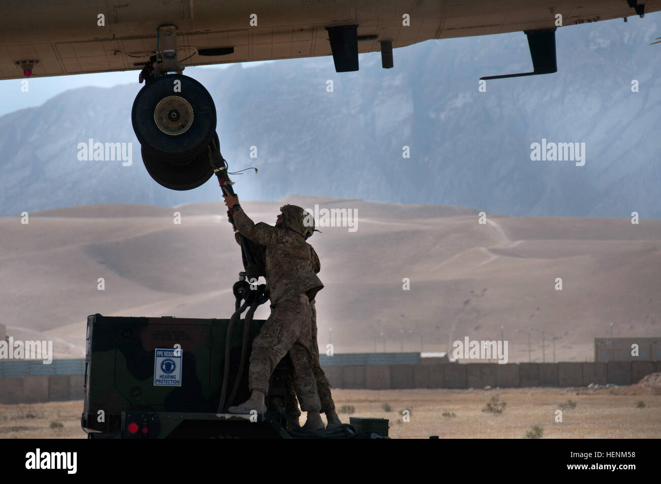 Soldaten, 1569th Transportation Company zugewiesen sichern die Cargo-Linie, der Chinook Lasthaken unter das Flugzeug mit Hilfe der Instruktoren. Die Piloten manövriert der Chinook direkt über das Gerät vor ungefähr neun Fuß über dem Boden schweben. (Foto von Sgt. Michael K. Selvage, 10. Sustainment Brigade Öffentlichkeitsarbeit NCO) (Freigegeben) Einhängen der Ladung 140630-A-CA521-274 Stockfoto