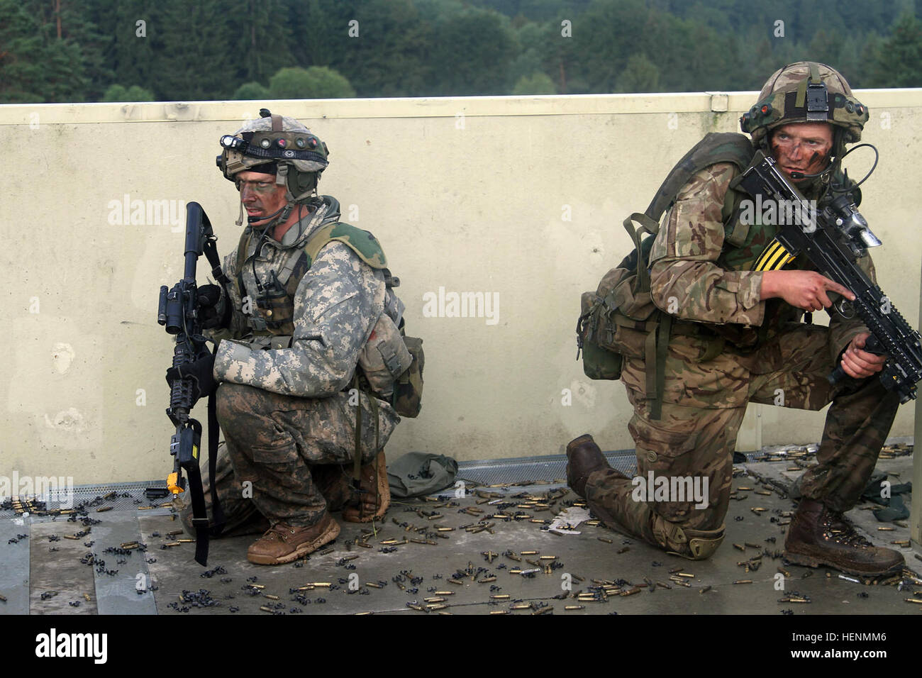 Britische Armee Royal Military Academy Sandhurst und US Military Academy in West Point Kadetten wachte vor Sonnenaufgang, Dorf-Clearing Manöver am Truppenübungsplatz Hohenfels, 15. Juli 2014 anzugehen. Die Kadetten haben seit dem 7. Juli in der US-Armee 7. Armee gemeinsame Multinational Training Command in Grafenwöhr und Hohenfels Übungsplätze trainiert. Sandhurst Kadetten absolvieren ihre letzte Übung vor Graduierung und der West Point Kadetten ihre Ausbildung von Führungskräften Entwicklung abgeschlossen werden. (Foto: US-Armee Sgt. Christina M. Dion, 319th Mobile Public Affairs-Abteilung) Sandhurst, Stockfoto