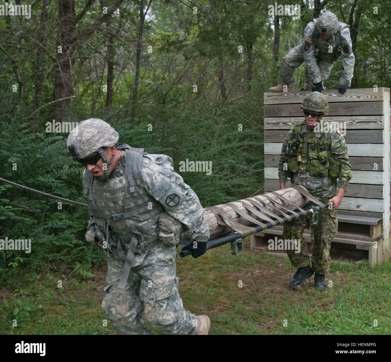 Sgt. Carlos Lopez, ein Aufklärungs-Sergeant aus Vancouver, Washington, mit dem 671st Ingenieur-Unternehmen aus Portland, Oregon/USA, und kanadische Sgt. Isaac Anderson, 33. kanadischen Brigade Group aus Ottawa, Ontario, befestigt an der 671st Ing. Co. beginnen, tragen ihre simulierten Unfall als Sgt. Christopher Manley, eine allgemeine Ausrüstung-Operator und Portland, Oregon, ansässig, auch mit der 671st Ing. Co. weiterleiten, löscht eine Wand beim konkurrieren in einem Hindernis-Parcours-Wettbewerb im Rahmen der Operation Fluss Angriff auf Fort Chaffee , Arche, July16. Die US Army Reserve-Einheit bewarben sich untereinander um die besten ti Stockfoto