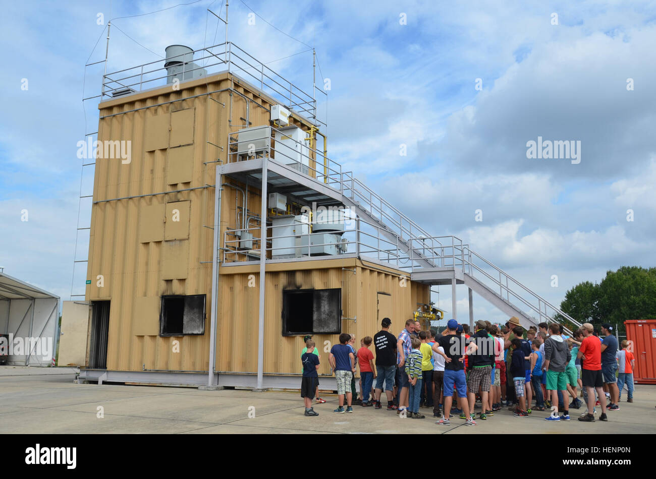Jungen von einem Sommer-Camp in Sielmingen Filderstadt, Deutschland, besuchte die Feuerwehr Training Center am US Army Garrison Ansbach Urlas Housing 7. August 2014. Juergen Schwab, Ausbildungsleiter in der Mitte, gab den Kindern einen Rundgang durch ihre Feuerwehrfahrzeuge sowie Einrichtungen, die Gebäude Feuer zu simulieren. Nach der Tour aßen die Kinder im Gehäuse Urlas Foodcourt. (US Armee-Foto von Bryan Gatchell, USAG Ansbach Public Affairs) Feuer Schulungseinrichtung 140807-A-FC388-004 Stockfoto