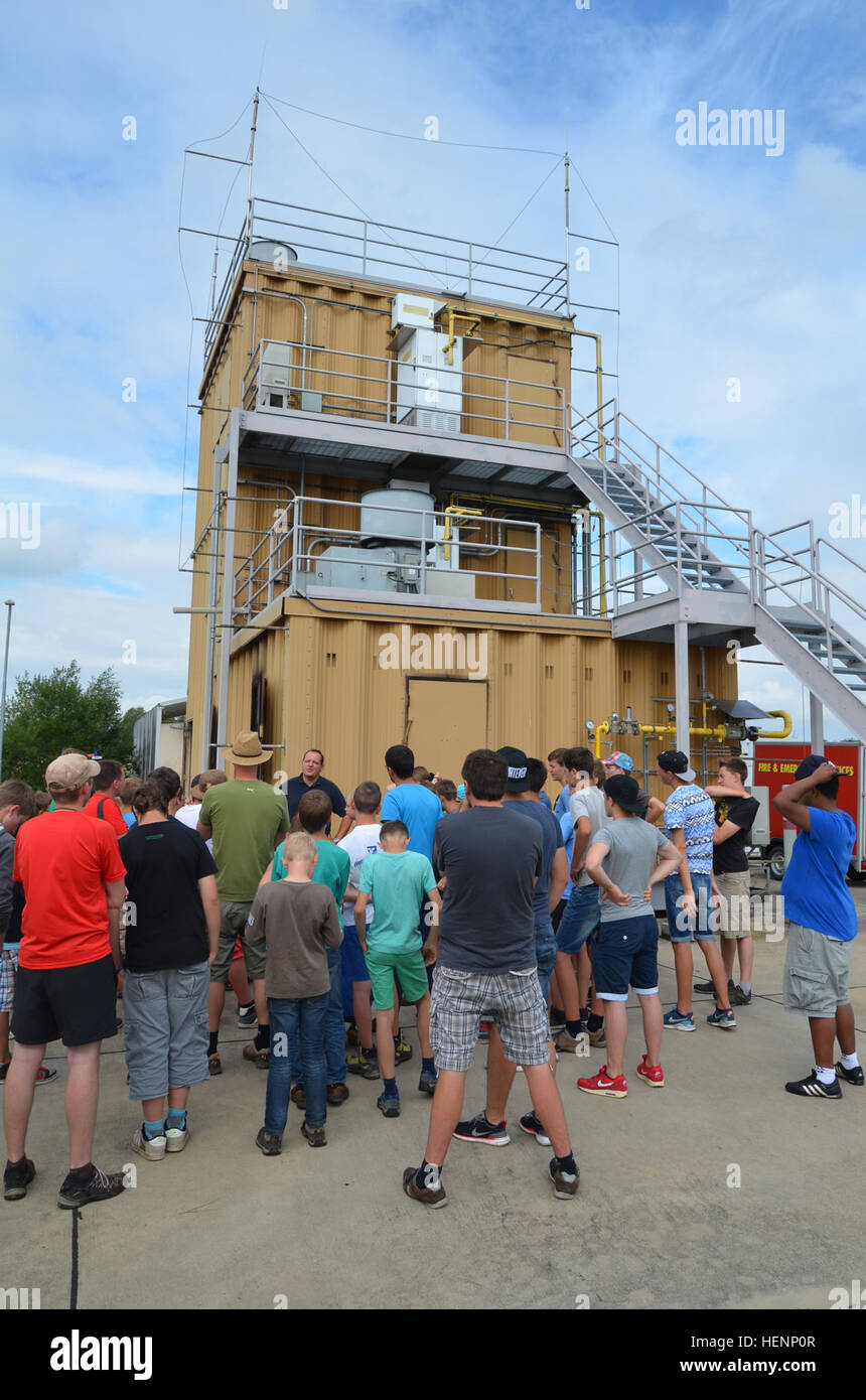 Jungen von einem Sommer-Camp in Sielmingen Filderstadt, Deutschland, besuchte die Feuerwehr Training Center am US Army Garrison Ansbach Urlas Housing 7. August 2014. Juergen Schwab, Ausbildungsleiter in der Mitte, gab den Kindern einen Rundgang durch ihre Feuerwehrfahrzeuge sowie Einrichtungen, die Gebäude Feuer zu simulieren. Nach der Tour aßen die Kinder im Gehäuse Urlas Foodcourt. (US Armee-Foto von Bryan Gatchell, USAG Ansbach Public Affairs) Feuer Schulungseinrichtung 140807-A-FC388-006 Stockfoto