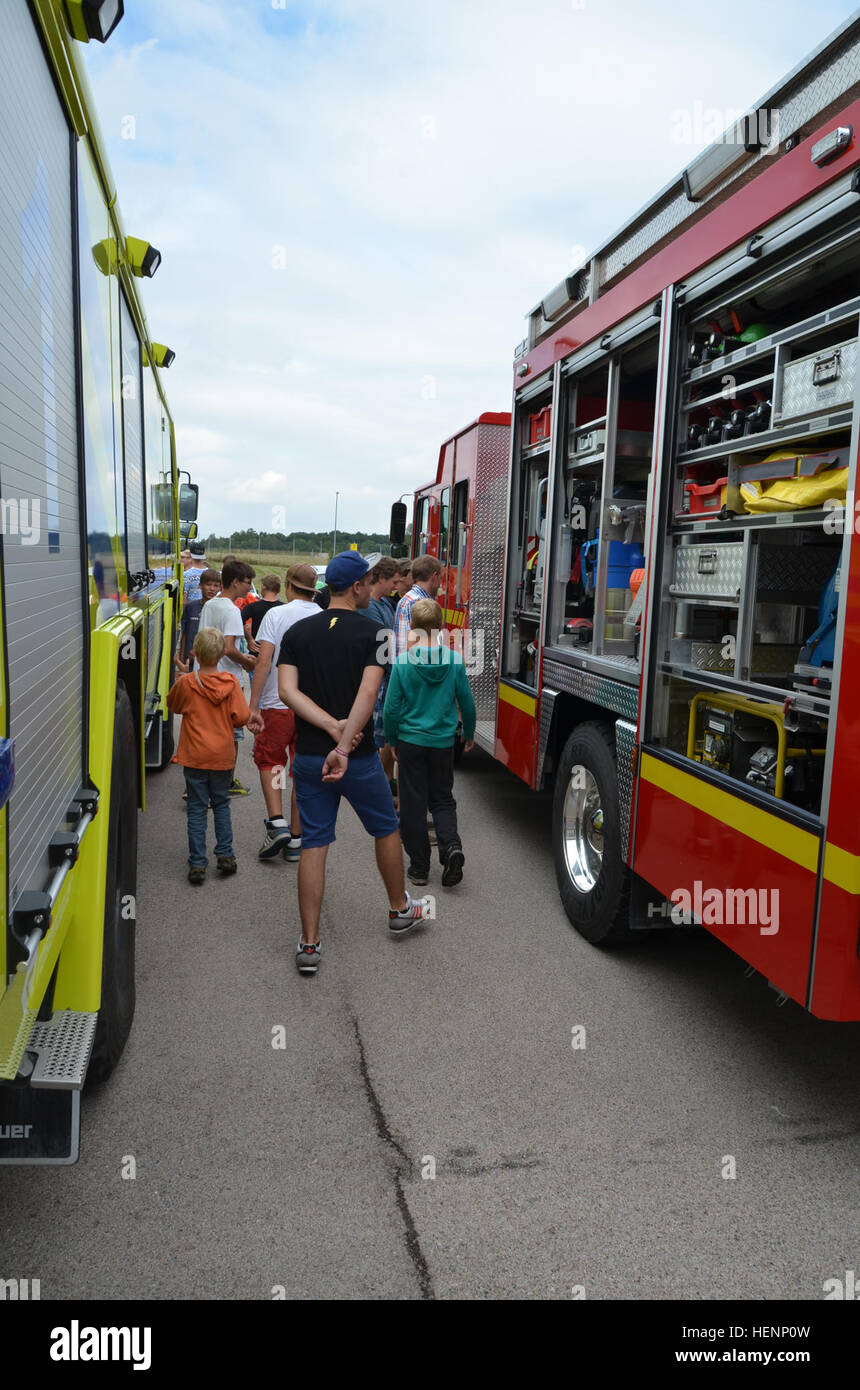 Jungen von einem Sommer-Camp in Sielmingen Filderstadt, Deutschland, besuchte die Feuerwehr Training Center am US Army Garrison Ansbach Urlas Housing 7. August 2014. Juergen Schwab, Ausbildungsleiter in der Mitte, gab den Kindern einen Rundgang durch ihre Feuerwehrfahrzeuge sowie Einrichtungen, die Gebäude Feuer zu simulieren. Nach der Tour aßen die Kinder im Gehäuse Urlas Foodcourt. (US Armee-Foto von Bryan Gatchell, USAG Ansbach Public Affairs) Feuerwehr 140807-A-FC388-007 Stockfoto