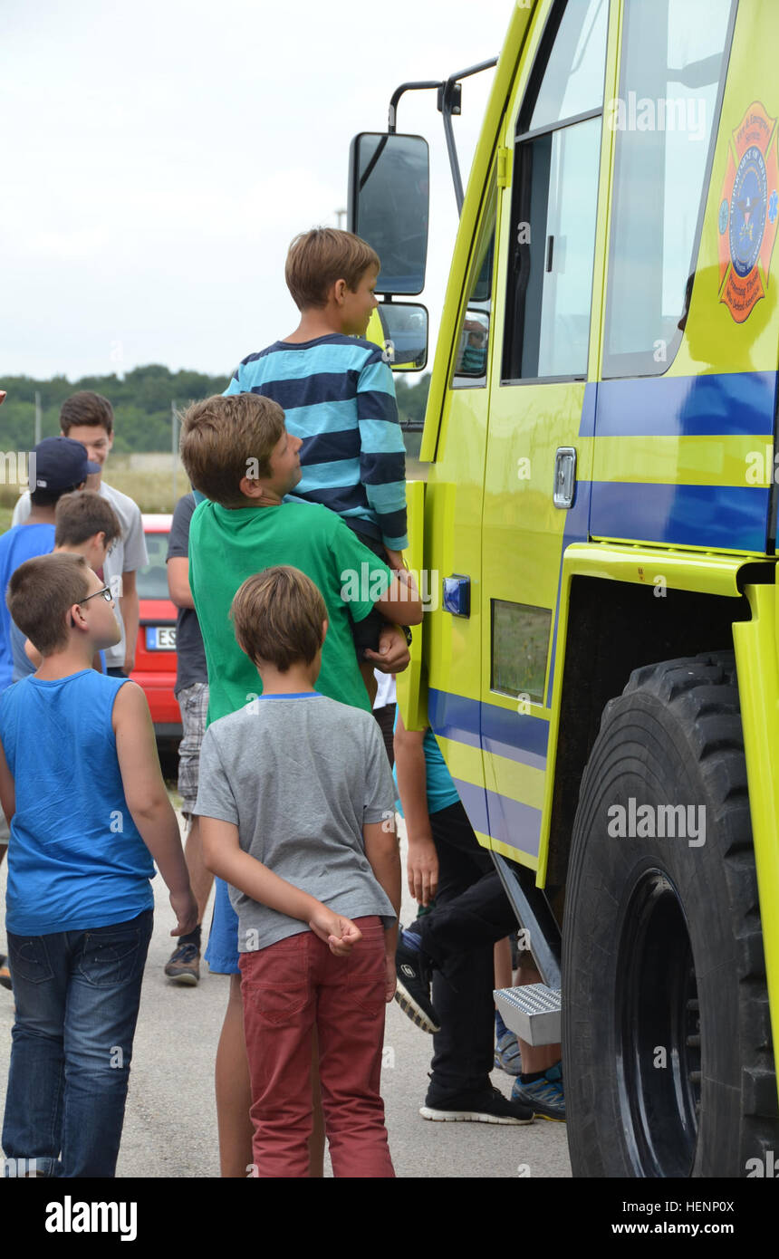 Jungen von einem Sommer-Camp in Sielmingen Filderstadt, Deutschland, besuchte die Feuerwehr Training Center am US Army Garrison Ansbach Urlas Housing 7. August 2014. Juergen Schwab, Ausbildungsleiter in der Mitte, gab den Kindern einen Rundgang durch ihre Feuerwehrfahrzeuge sowie Einrichtungen, die Gebäude Feuer zu simulieren. Nach der Tour aßen die Kinder im Gehäuse Urlas Foodcourt. (US Armee-Foto von Bryan Gatchell, USAG Ansbach Public Affairs) Feuerwehr 140807-A-FC388-008 Stockfoto