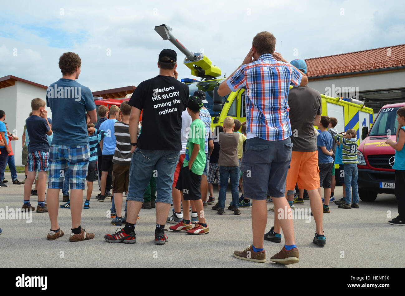 Jungen von einem deutschen Sommer-Camp Ohren ihre als das Feuerwehrauto Sirenen schmettern. Die Kinder von einem Sommer-Camp in Sielmingen Filderstadt, Deutschland, besuchte die Feuerwehr Training Center am US Army Garrison Ansbach Urlas Housing 7. August 2014. Juergen Schwab, Ausbildungsleiter in der Mitte, gab den Kindern einen Rundgang durch ihre Feuerwehrfahrzeuge sowie Einrichtungen, die Gebäude Feuer zu simulieren. Nach der Tour aßen die Kinder im Gehäuse Urlas Foodcourt. (US Armee-Foto von Bryan Gatchell, USAG Ansbach Public Affairs) Sirene 140807-A-FC388-010 Stockfoto