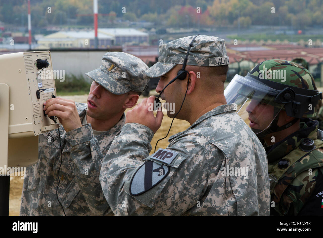 Sgt. 1. Klasse Ivan Alvira, ein Militär-Polizist aus Sitz, Stabskompanie, 1. Brigade Combat Team, 1. Kavallerie-Division, führt eine Systeme überprüfen auf einem Massenkontrolle Lautsprecher als 2nd Lt. James Bain, ein Offizier der Militärpolizei mit 89. Military Police Brigade, die Kontrollen, um eine bulgarische Militärpolizist erklärt. (Foto: US-Armee Sgt. Alexander Skripnichuk, 7. Mobile Public Affairs-Abteilung) Die Grundlagen der Massenkontrolle 141029-A-DU810-056 Stockfoto