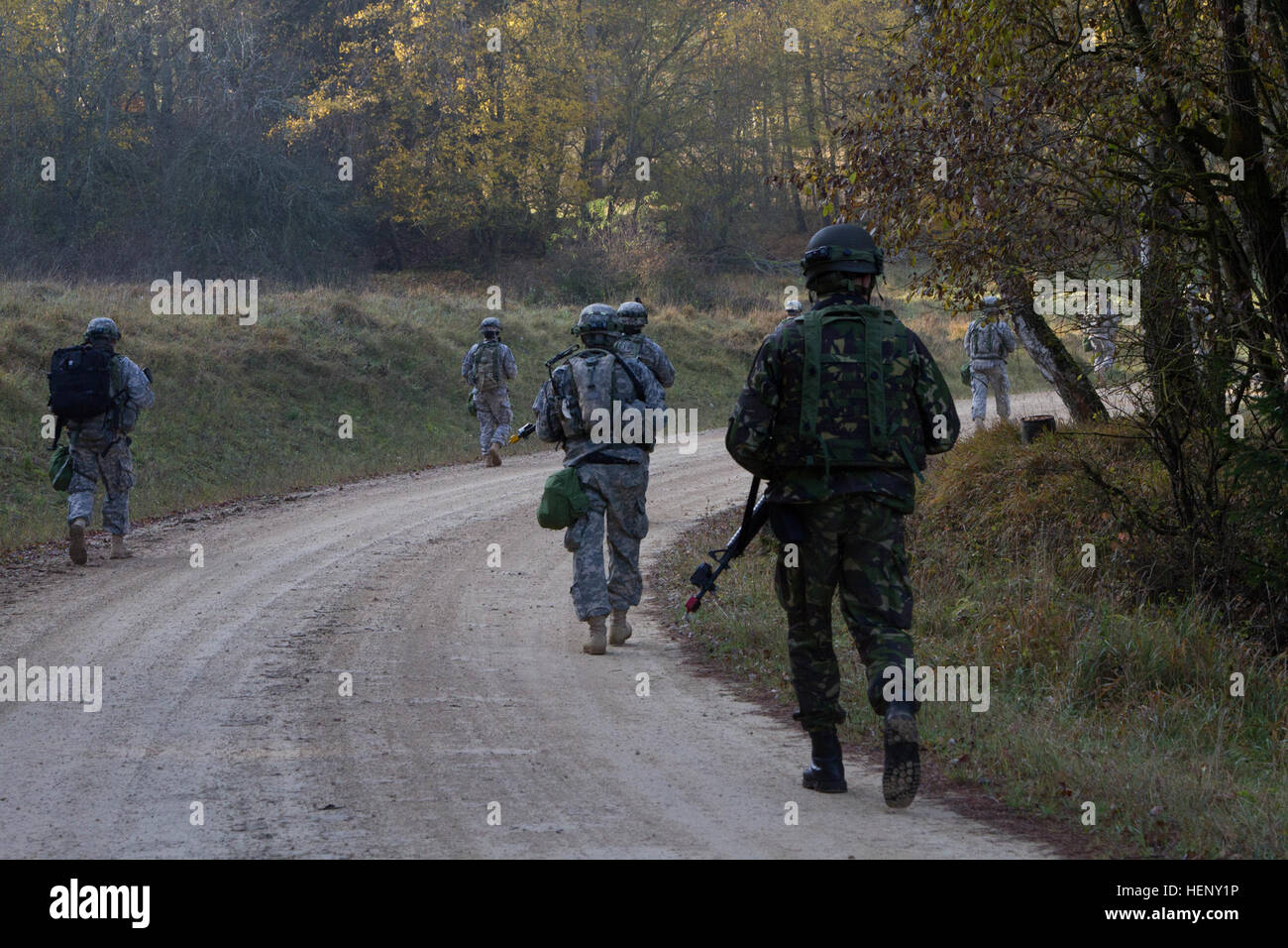 Soldaten aus 1st Brigade Combat Team, 1. Kavallerie-Division und Rumänien marschieren in Richtung eines Dorfes während einer Übung in Hohenfels, Deutschland, November 3, als Teil der Lösung III kombiniert.  (Foto: US-Armee Sgt. Alexander Skripnichuk, 7. Mobile Public Affairs-Abteilung) Bau Interoperabilität einen Straße März zu einem Zeitpunkt 141103-A-DU810-065 Stockfoto