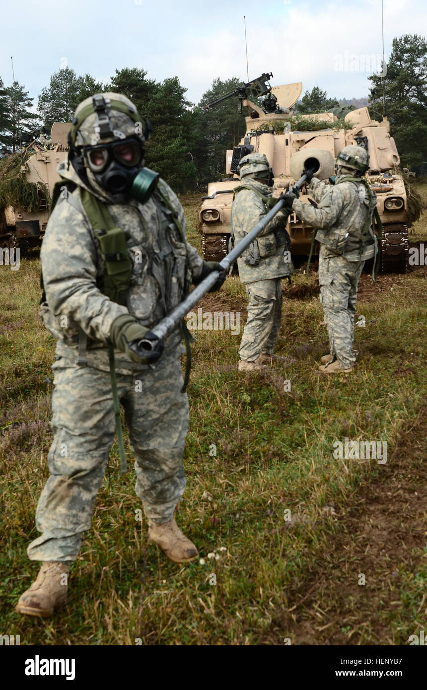 US-Soldaten des 1. Bataillons, 82. Feldartillerie-Regiment, 1st Brigade Combat Team, 1. Kavallerie-Division den Lauf der a155-mm-Haubitze reinigen während des Tragens Mission orientierten schützende Haltung Ausrüstung während des Trainings kombiniert Entschlossenheit III bei der Joint Multinational Readiness Center in Hohenfels, Deutschland, 8. November 2014.  Kombinierte Lösung III ist eine multinationale Übung, die enthält mehr als 4.000 Teilnehmer aus NATO und Partner, und soll eine komplexe Trainingsszenario bieten, die konzentriert sich auf multinationale unified Land Operationen und stärkt das US-Engagement der NATO und Stockfoto