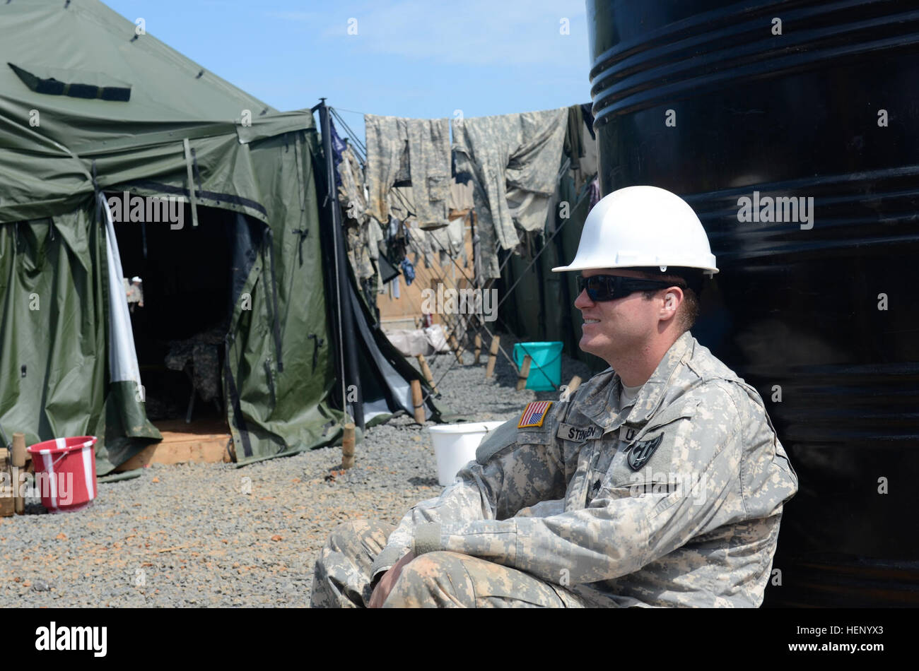 Sergeant Erik Stensen, Techniker, 534th Engineer Detachment, 15. Pionier-Bataillon, 18. Ingenieur-Brigade, 21. Sustainment Command, findet eine kurze Pause von der heißen, anstrengenden Arbeit in Buchanan, Liberia, 17. November 2014. Obwohl die Ingenieure allgemeine Annehmlichkeiten, wie Waschmaschinen und Duschen fehlen, arbeiten sie Tag und Nacht um die Ebola-Behandlungseinheit für die Menschen in Buchanan gebaut. Betrieb United Hilfe ist eine Operation des Verteidigungsministeriums in Liberia Logistik, Schulung und technische Unterstützung US Agentur für internationale Entwicklung-geführten Bemühungen, Apart Stockfoto