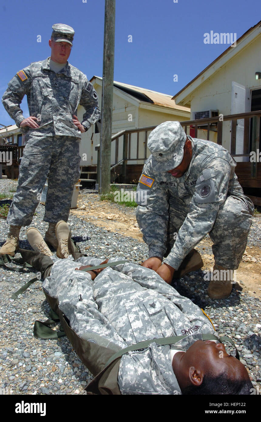 Armee Spc. Angel Benitezbatista sichert Armee Sgt. Marquita Williams einen Wurf, während Armee Sgt. Joshua Bane während einer Bekämpfung der Lebensretter bei Joint Task Force Guantanamo Camp America, 5. Juni 2008 schaut. Armee-Personal-Sergeant Christopher Ellis führte die Klasse die nichtmedizinische lehrt, dass Soldaten erweiterte lebensrettende Ausbildung zur Notfallversorgung als sekundäre Mission zur Verfügung zu stellen. JTF Guantanamo führt durch sichere und humane Pflege und Obhut von Festgenommenen feindlichen Kämpfern. Die JTF führt Verhör Operationen um strategische Intelligenz zur Unterstützung der globalen Krieg gegen den Terror zu sammeln und unterstützt Gesetz enfo Stockfoto