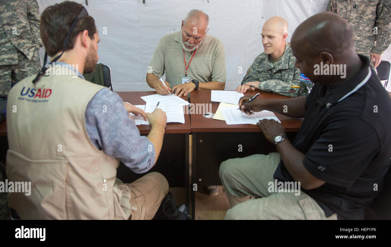 Von links, Sam Vigersky, account Manager bei der US Agency for International Development, Dr. Rene' Vega, leitender medizinischer Offizier mit Herz zu Herz International, Major Ken Bulthuis, Joint Forces Command – United Hilfe und Willis Plummer, Bauleiter für PAE, Papierkram Übergabe einer abgeschlossenen Ebola Behandlungseinheit an die internationalen Hilfsorganisationen in Tappita, Liberia, 27. Dezember 2014 zu unterzeichnen. Vereinte Hilfe ist eine US-Verteidigungsministerium Operation Befehl und Steuerung, Logistik, Schulung und technische Unterstützung US Agentur für internationale Entwicklung-geführten Bemühungen, cont Stockfoto