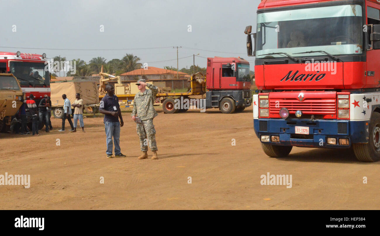Sgt. Marc Hillary, rechts, eine Goodyear, Arizona, Native und eine Einheit Bewegung Unteroffizier verantwortlich für Headquarters und Headquarters Company, 62. Pionier-Bataillon 36. Engineer Brigade Slips General Bah, liberianische LKW-Fahrer, auf wie viele Container, die auf den nicht-taktischen Fahrzeugen Buchanan, als Bestandteil der Einheit Übergang zurück in die USA zur Unterstützung der Operation United Hilfe gehen , United joint Forces Command – Hilfe, an der National Police Training Academy, Paynesville, Liberia. Sobald alle Container geladen sind, sind sie in den Stagingbereich in Bu getroffen. Stockfoto