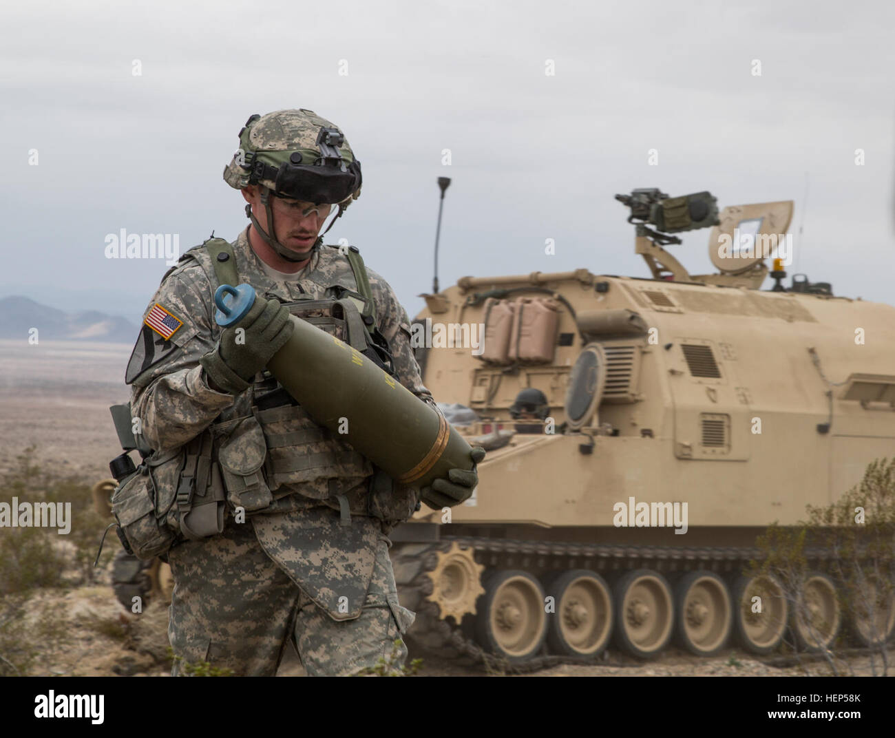 Ein US-Soldat von Alpha Company, 2nd Brigade Combat Team, 82nd Feldartillerie-Regiment, 3. Bataillon, 1. Kavallerie-Division lädt 155mm Kanone Runden in eine M109A6 Paladin während der entscheidenden Aktion Rotation 15-05 an die National Training Center in Fort Irwin, Kalifornien, 22. Februar 2015. Die entscheidende Aktion Trainingsumgebung wurde entwickelt, um ein häufiges Trainingsszenario für den Einsatz der Armee zu schaffen. (US Armee-Foto von Sgt. Richard W. Jones Jr./freigegeben) Soldaten laden Munition vor angreifenden Kräfte Enermy 150222-A-QU939-049 Stockfoto