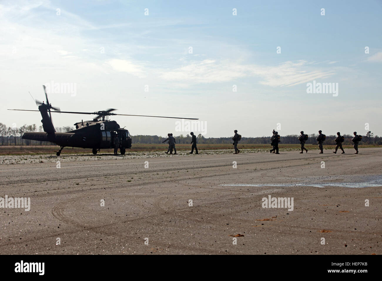 Fallschirmjäger Fuß zu einem UH-60 Black Hawk im Betrieb "Skyfall" Nightstalker Drop Zone, Sylvania, Ga., 20. März 2015. Betrieb "Skyfall" ist die gemeinsame, multilaterale Bekämpfung Kamera Gegenstand Expertenaustausch, veranstaltet von der 982nd Combat Camera-Company (Airborne), an mehreren Standorten in Georgien stattfindet. Betrieb "Skyfall" ist eine Veranstaltung, die konzentriert sich auf die Interoperabilität der Bekämpfung Kamera training und Erfassung Luftlandeoperationen mit drei Partnernationen und Multi-service-Einheiten. (US Armee-Foto von Spc. Tracy McKithern/freigegeben) Betrieb "Skyfall" 2015 150320-A-LC197-551 Stockfoto