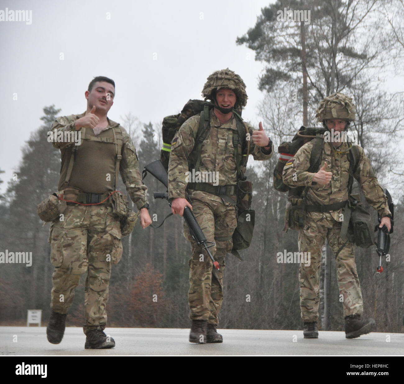 Laufen mit Pvt. Matthew Alexander (links), ihre unterstützenden Kameraden, Lance Cpl. Peter Andrew (Mitte) und Pvt. Joseph Hazel (rechts) das Vereinigte Königreich 1 gepanzerte Medical Regiment geben eine Daumen-hoch gefragt, wie sie bei Meile 9 fühlten. Andrew und Hazel waren zwei der fünf internationalen Kandidaten, die am 27. März ihre Medaille verliehen. Verbündeten verdienen das Abzeichen 150327-A-UA479-295 Stockfoto