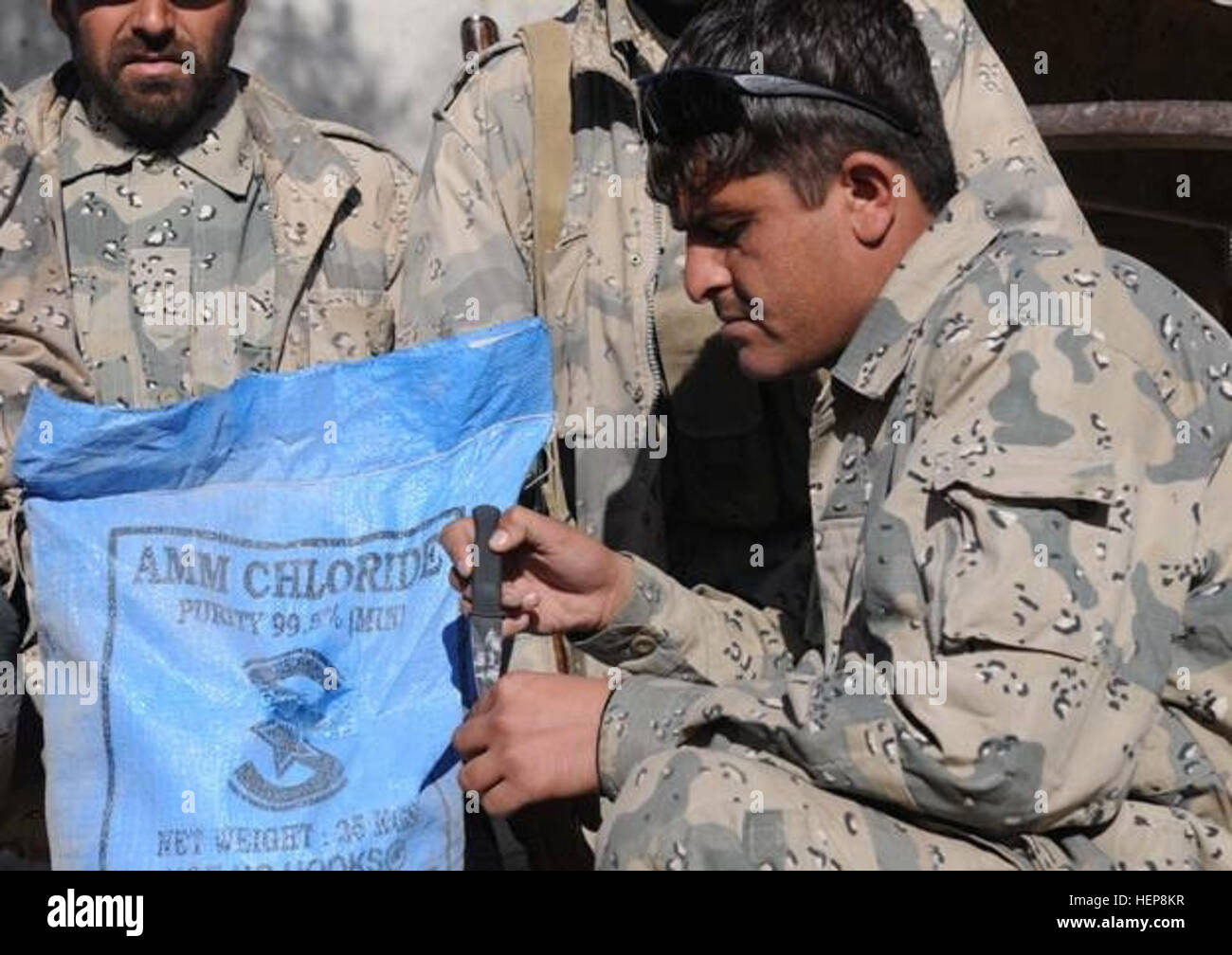 Ein afghanischer Grenzpolizeibeamter inspiziert mutmaßliche selbstgemachte Sprengstoffe in einem lokalen Zentrum in Spin Boldak, Provinz Kandahar, als Teil von Grenzsicherheits- und Sprengstoffbekämpfungsoperationen. Stockfoto