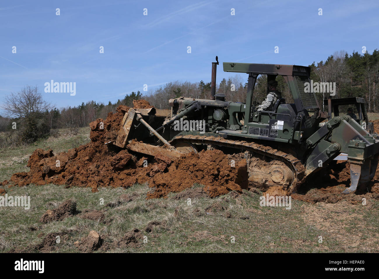 US-Soldaten des Regiments Engineer Squadron, 2. Kavallerie-Regiment verwenden eine Planierraupe, um Tank Gräben zu graben, während Bau defensive Hindernisse während Saber Kreuzung 15 an die US Army Joint Multinational Readiness Center in Hohenfels, Deutschland, 14. April 2015 ausüben. Säbel Kreuzung 15 bereitet NATO und Partnerland Streitkräfte für Offensive und Defensive Stabilität Operationen und fördert die Interoperabilität zwischen den Teilnehmern. Säbel Kreuzung 15 hat mehr als 4.700 Teilnehmer aus 17 Ländern enthalten: Albanien, Armenien, Belgien, Bosnien, Bulgarien, Großbritannien, Ungarn, Lettland, Litauen Stockfoto