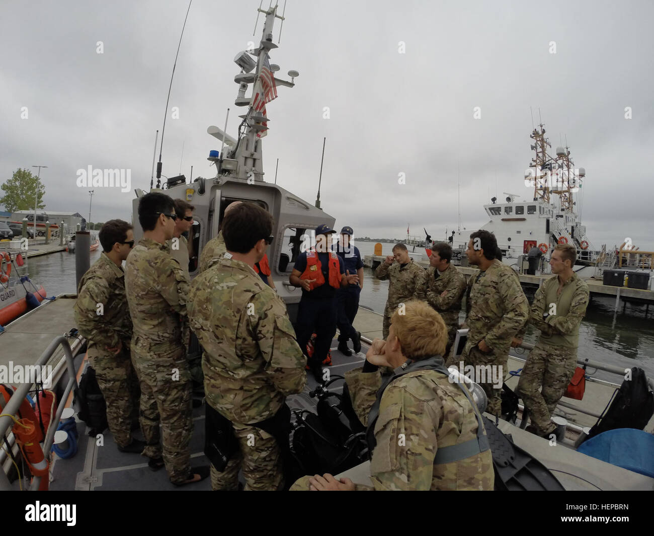 Army National Guard Special Forces Kampftaucher auf den Tauchgang hören kurz von Mitgliedern der US-Küstenwache auf dem Deck der Küstenwache 45' Antwort Boot-Medium am Naval Station Mayport, Florida, 27. April 2015. Die 20. Special Forces Group (Airborne) Mitglieder arbeiteten mit der Küstenwache zu verbessern maritime Kenntnisse und Fähigkeiten für beide Komponenten zu erweitern. (Foto: SSG Adam Fischman Nationalgarde) Armee Garde SF Kampftaucher trainieren mit USCG 150427-A-KC506-236 Stockfoto