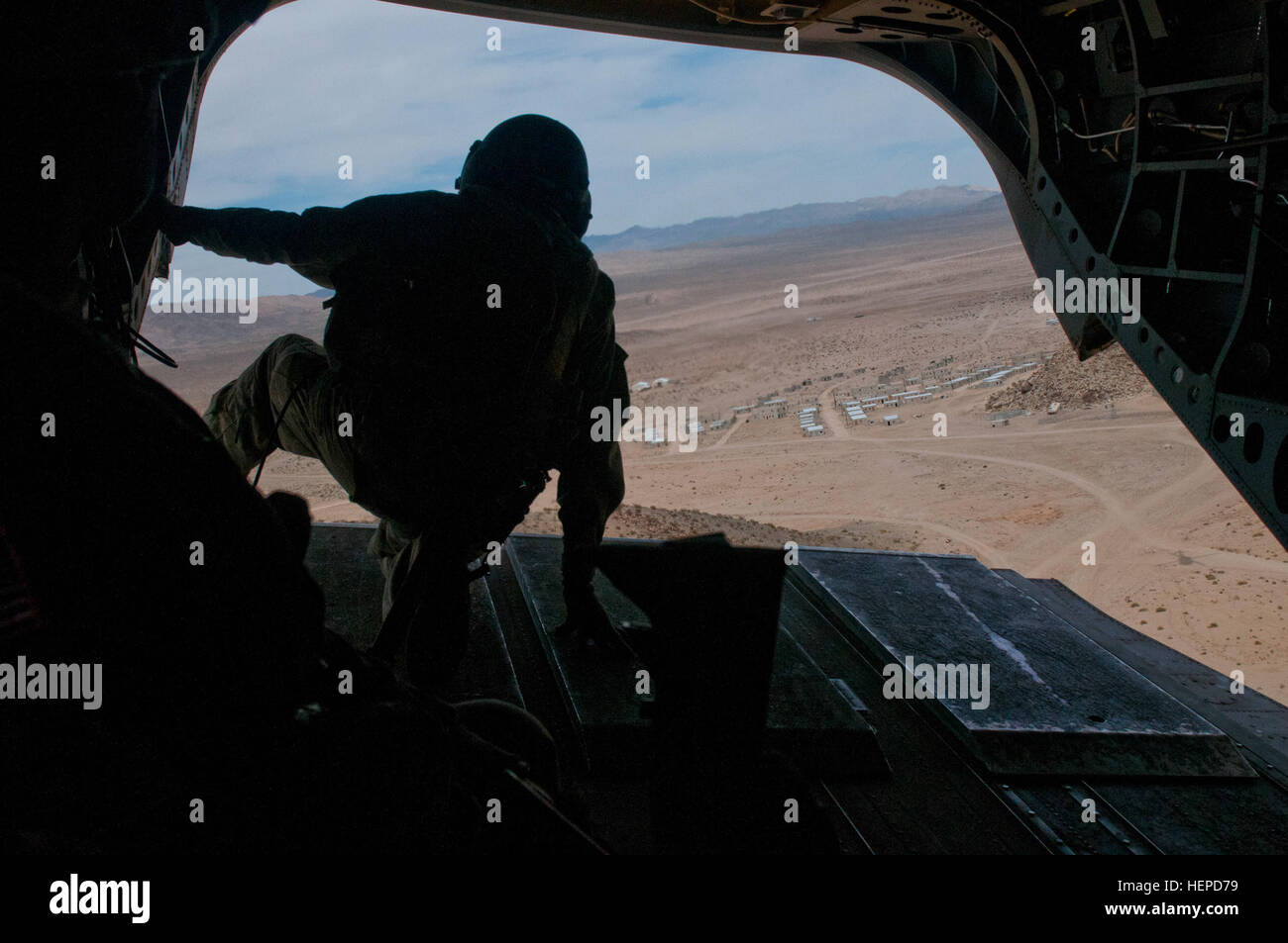 Ein UH-64 Chinook-Crew-Mitglied mit der 1. Kavallerie-Brigade der Luft, hält 1. Kavallerie-Division an einem Griff wie die Luft zum Handwerk mock stadtauswärts in die National Training Center, 1.Mai an Fort Irwin, Kalifornien fliegt Das Flugzeug wurde verwendet, um die Soldaten mit der 3. Pionierbataillon abholen, 3rd Armored Brigade Combat Team, wie sie aus der Stadt evakuiert. (US Armee-Foto von Sgt. Brandon Banzhaf, 3rd Armored Brigade Combat Team, 1. Kavallerie-Division) 3. ABCT NTC Drehung 150501-A-FJ427-495 Stockfoto