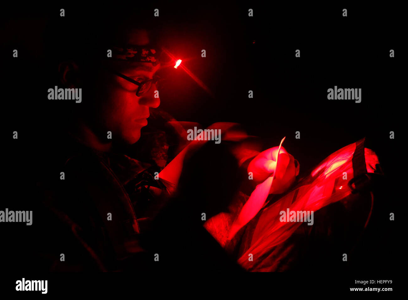 Durch das rote Licht seiner Stirnlampe studiert Pvt. Anthony Smith, ein Infanterist, 5. Staffel, 73. Airborne Kavallerie-Regiment, 3rd Brigade Combat Team, 82nd Airborne Division, zugewiesen eine Karte von Fort Bragg, N.C., während der Land Navigation Teil des langen Überwachung Bereichswahl, 23.Juni. Kandidaten begann ihre zweite Tag der Auswahl auf dem Land Navigation Kurs auf 03:00, im Wettbewerb um eine Chance, ein Teil der F Company (Long-Range-Überwachung), Hauptquartier Bataillon, XVIII Airborne Corps sein. (Foto: US Army Spc. Paige Behringer, 10. Press Camp Sitz) Long-Range-Surveillanc Stockfoto