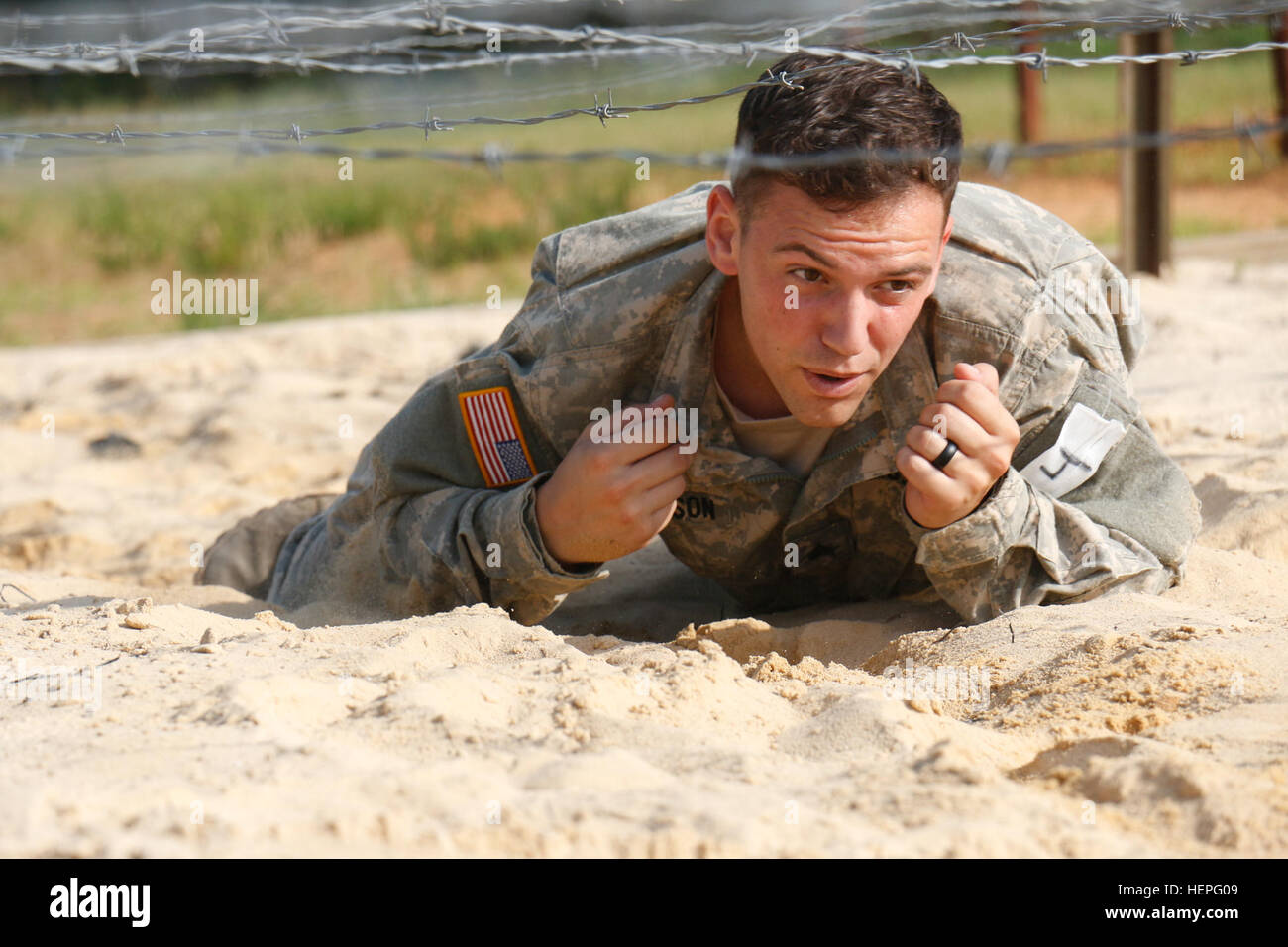 Sgt. Joe Anderson, ein Infanterist, Firma A, 1. Bataillon, 325. Airborne Infanterie-Regiment, 2nd Brigade Combat Team, 82nd Airborne Division, niedrig kriecht durch einen Sandkasten unter Stacheldraht an ein Hindernis-Parcours bei der letzten Etappe des langen Überwachung Bereichswahl, 24. Juni, um Fort Bragg, N.C.-Kandidaten zugewiesen bekamen zwei Versuche, jedes Hindernis erfolgreich zu navigieren, bevor sie durch Kader ausziehen gesagt wurden. (Foto: US Army Spc. Paige Behringer, 10. Press Camp Sitz) Long Range Surveillance Auswahl 150624-A-HL390-326 Stockfoto