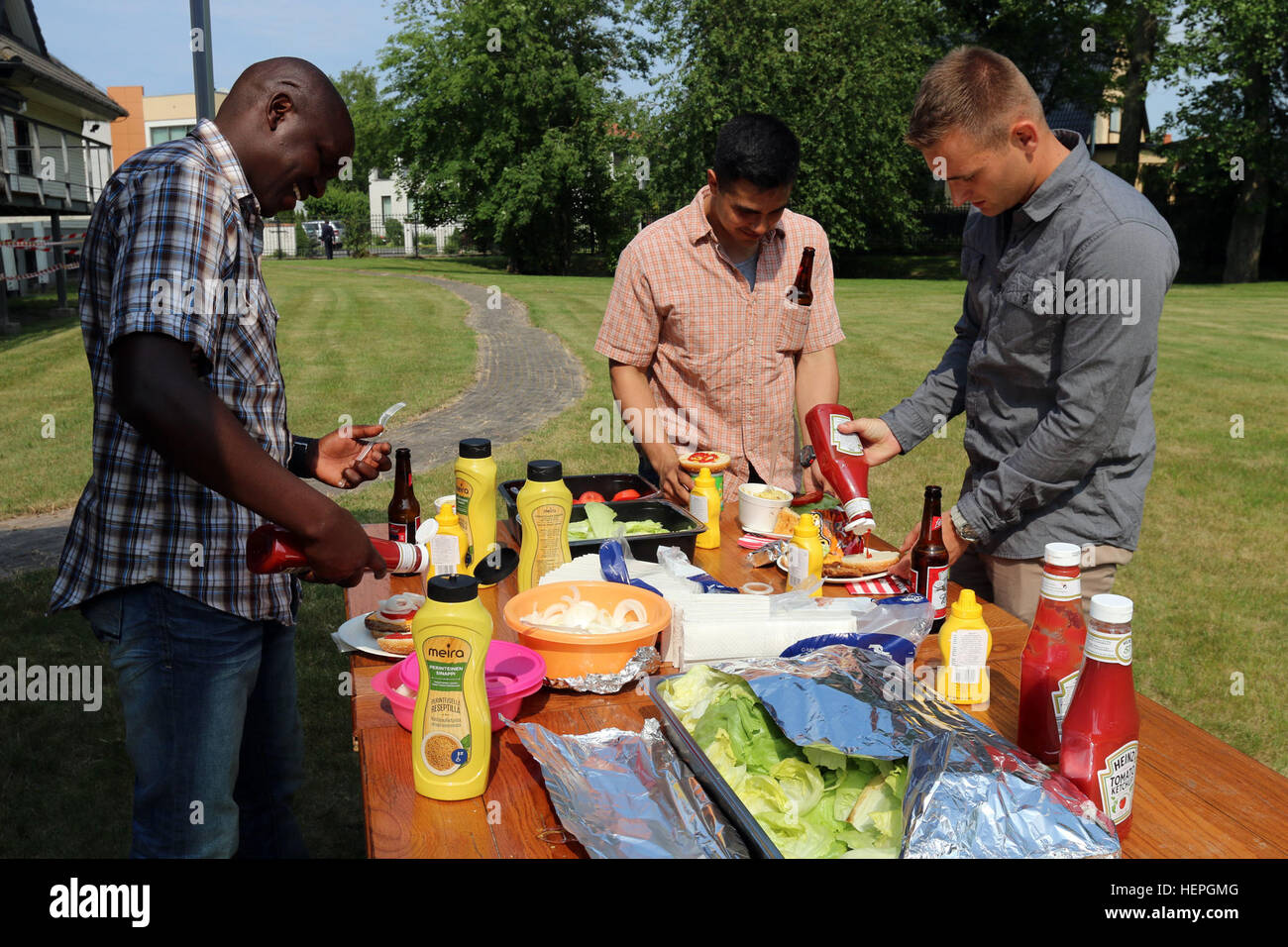 Soldaten mit bestimmt Company, 2. Bataillon, 503. Infanterieregiment 173rd Airborne Brigade, Picknick eine amerikanische während einer vierten Juli Party veranstaltet von der Marine-Abteilung bei der amerikanischen Botschaft in Tallinn, Estland, Juli 4. Genossen auf der Party waren Cornhole werfen Spiele, Musik und Fußball als die amerikanischen Soldaten kam ihre Marine-Kollegen als sie den amerikanischen Feiertag zusammen weg von zu Hause feierten. (US Armee-Foto von Spc. Jacqueline Dowland, 13. Public Affairs-Abteilung) Eine amerikanische Fourth Of July in Estland 150704-A-VD071-003 Stockfoto