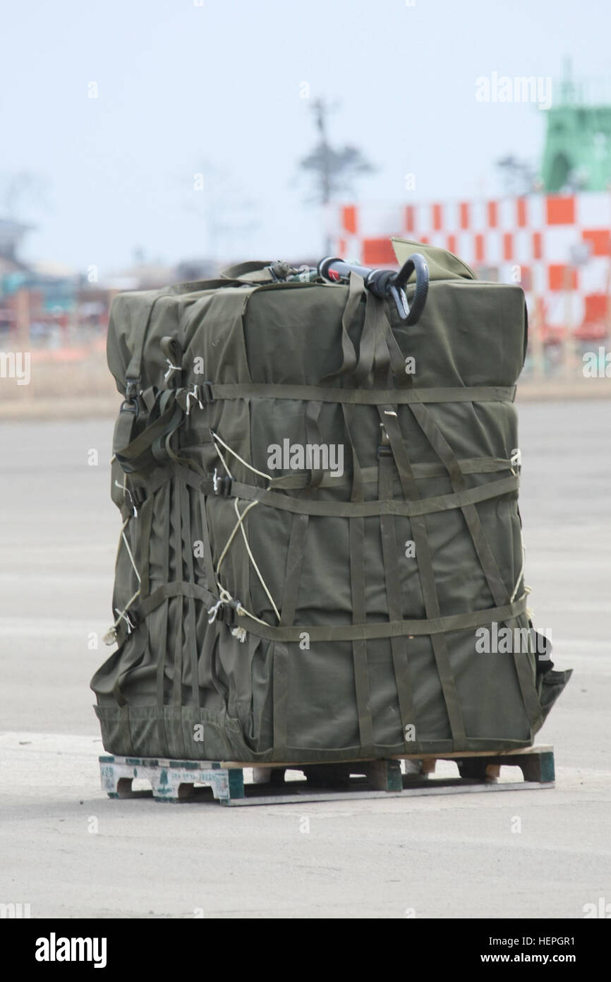 Eine Last, bestehend aus 3800 lbs Wasser gebunden für Okushima, Japan, erwartet einen UH-60 Black Hawk-Hubschrauber auf dem Rollfeld in Sendai Airport. US Army Japan unterstützt die gemeinsame Kraft Land Component Command bei der Unterstützung der Vertriebenen japanischen betroffenen Bürgerinnen und Bürger von dem 11. März Erdbeben und Tsunami während der Operation Tomodachi. Slingload Nachschub 385874 Stockfoto