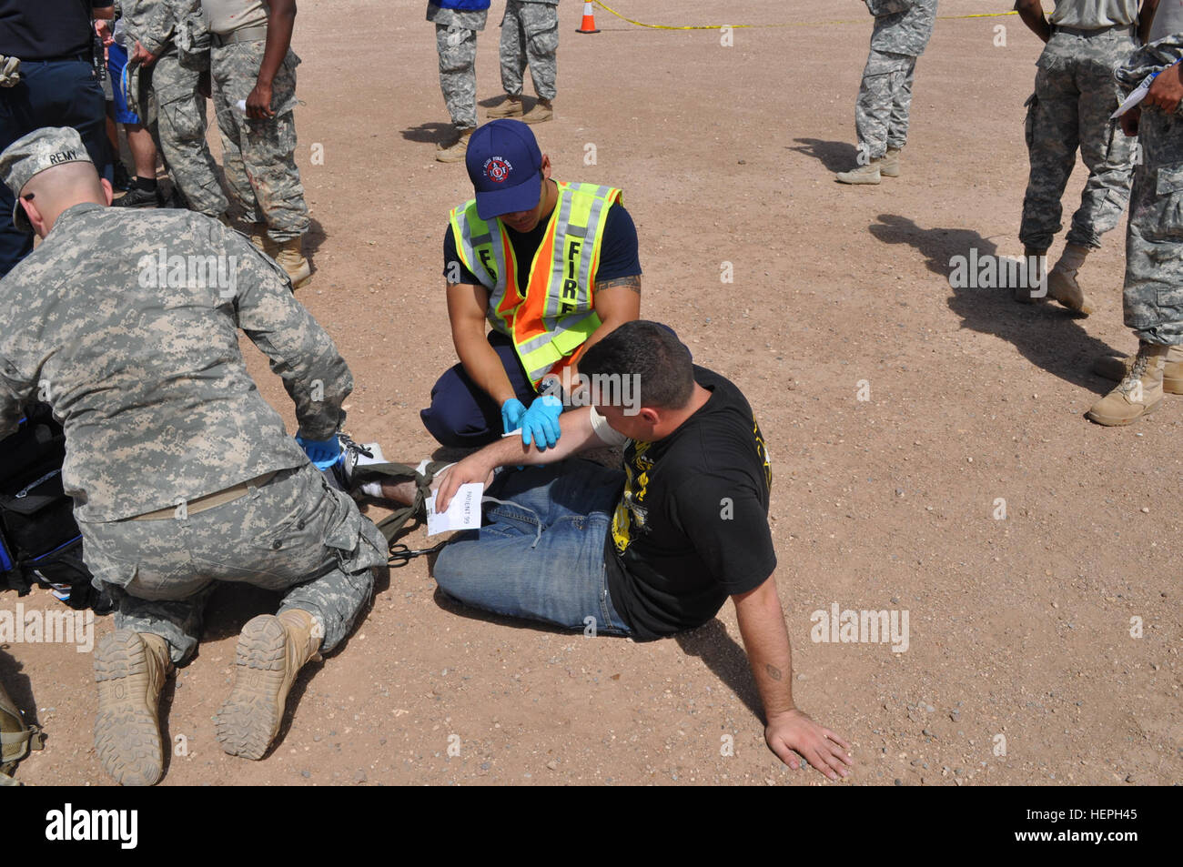 Ein Feuerwehrmann mit Fort Bliss Feuerwehr bietet erste Hilfe für einen verletzten Rollenspieler während Eisen Reaktion, eine aktive Schütze-Übung, die die Soldaten Belastbarkeit und Readiness Center auf West Fort Bliss 9 Juli stattfand. Eisen-Reaktion, auf dem Boden einer aktiven Shooter Übung 150709-A-CX902-015 Stockfoto