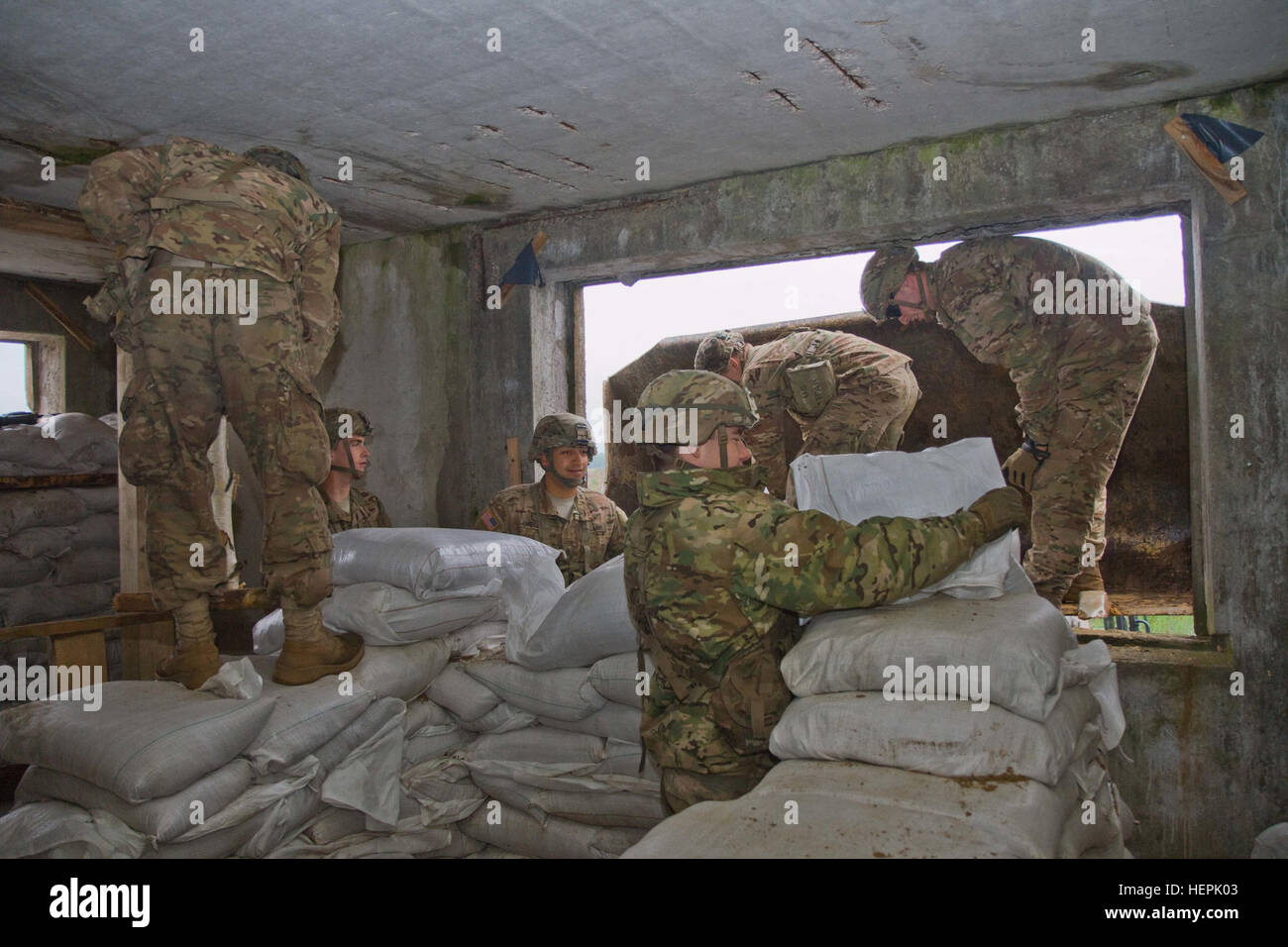 US Army Fallschirmjäger von Dog Company, 1. Bataillon, Sandsäcke 503. Infanterieregiment, 173rd Airborne Brigade, Stapel auf der zweiten Etage eine Struktur, die sie während der Übung Ingenieur Thunder 2015 anlässlich der großen litauischen Hetman Jonusas Radvila Training Regiment, in Rukla, Litauen, Sept. 9, 2015 Abwehrmechanismen für Gebäude sind. Der 173rd Airborne Brigade arbeitete neben der litauischen Landstreitkräfte Partner, General Engineer Coy, Juozas Vitkus Engineer Battalion, mehr winterharte Verteidigung mit Frontlader, Bagger und Traktoren zu montieren. Ingenieur-Thunder wird beider Länder Abi verbessern. Stockfoto