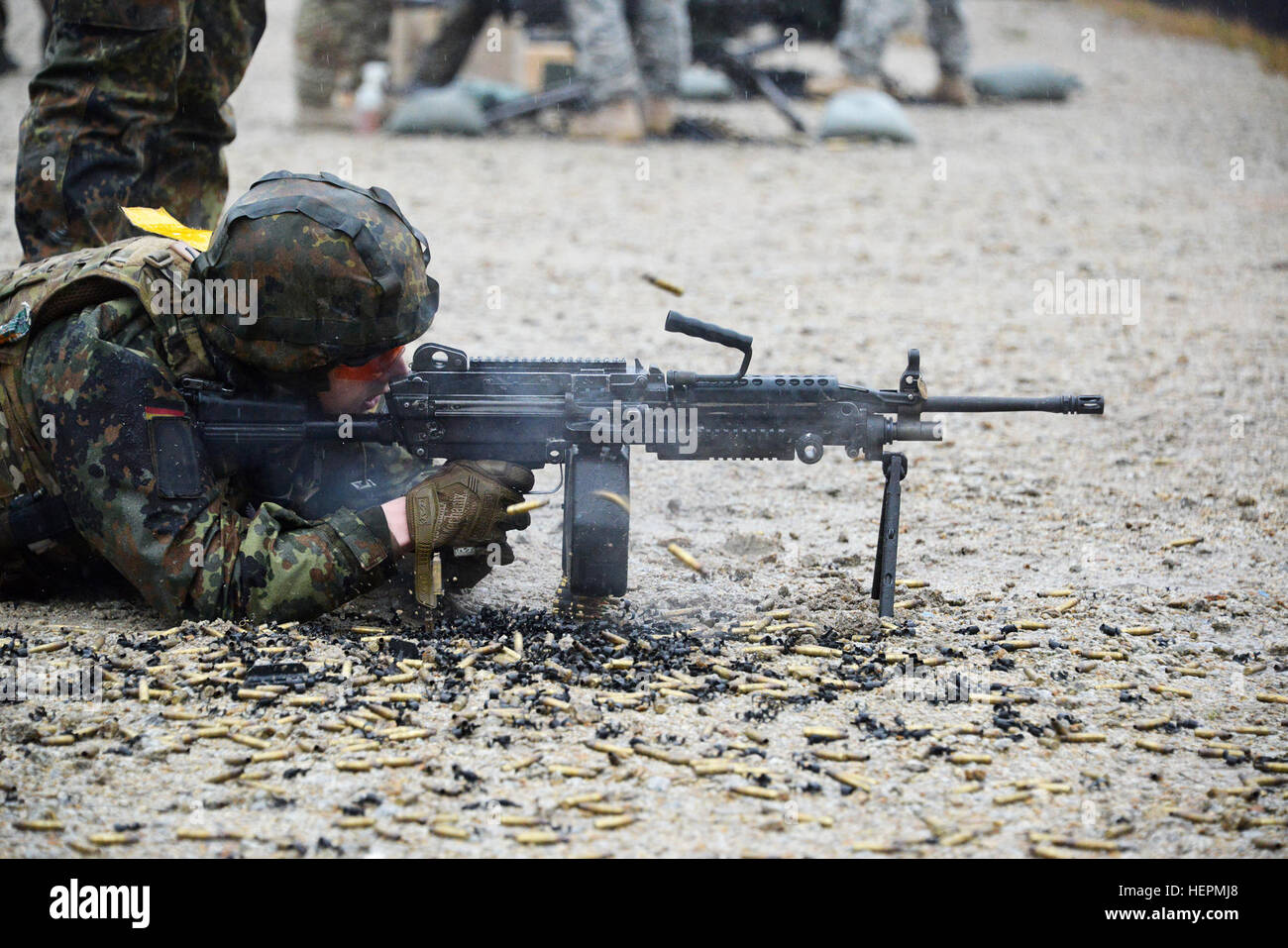 Ein deutscher Soldat feuert eine leichtes Maschinengewehr M249 während einer Einarbeitung Ausbildung auf US-Waffen im 7. Armee multinationale Ausbildung Befehl Grafenwöhr Training Ballenbereich, Deutschland, 9. Dezember 2015. (US Army Foto von visuellen Informationen Spezialist Gertrud Zach/freigegeben) D-Züge deutscher Soldaten auf uns Waffen 151209-A-HE539-0858 Stockfoto