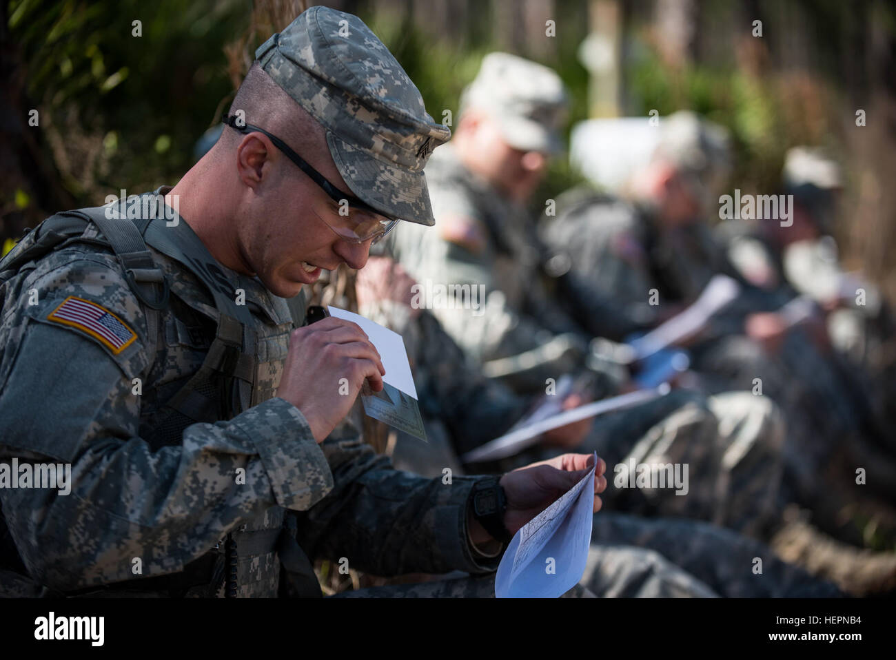 Sgt. Jordan Lepley, ist ein US Army Reserve Militärpolizei Soldat mit der 317th Military Police Battalion, der neue Cumberland, Pennsylvania, packt seine Winkelmesser und Notecard aus seinem Mund zu Beginn einer Land-Navigation in diesem Jahr natürlich 200. Militärpolizei Befehl beste Krieger Wettbewerb im Camp Blanding, Florida, 9 Februar statt. Die preisgekrönte Unteroffizier und junior eingetragene Soldaten kommen zur US Army Reserve Command-Wettbewerb im Mai. (Foto: U.S. Army Master Sgt. Michel Sauret) Navigieren durch Florida Wald 160209-A-TI382-330 Stockfoto