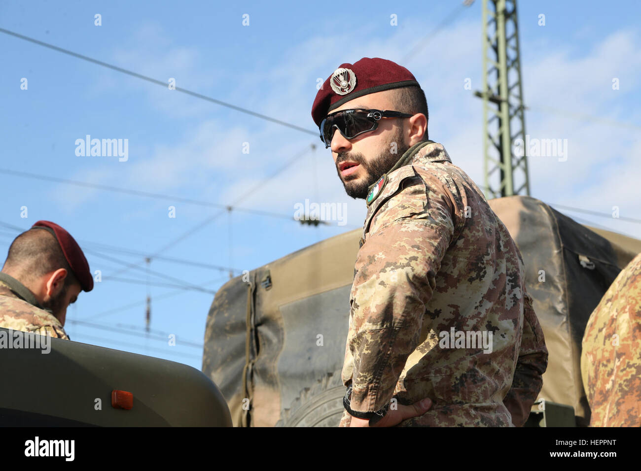 Ein italienischer Soldat Folgore Fallschirm Brigade beobachtet Humvee ist von Schienenfahrzeugen in Vorbereitung auf einen Konvoi während des Trainings Saber Junction 16 an der US-Armee gemeinsamen multinationalen Readiness Center (JMRC) in Hohenfels, Deutschland, 7. April 2016 entladen wird. Säbel Junction 16 ist der US-Army Europe 173rd Airborne Brigade Kampftraining Zentrum Zertifizierung Übung stattfindenden JMRC in Hohenfels, Deutschland, Mrz 31-Apr 24, 2016.  Die Übung soll die Bereitschaft der Europa-basierte Kampfbrigaden zu einheitlichen Land-Operationen durchzuführen und zu fördern Interoperabi für die Armee zu bewerten Stockfoto