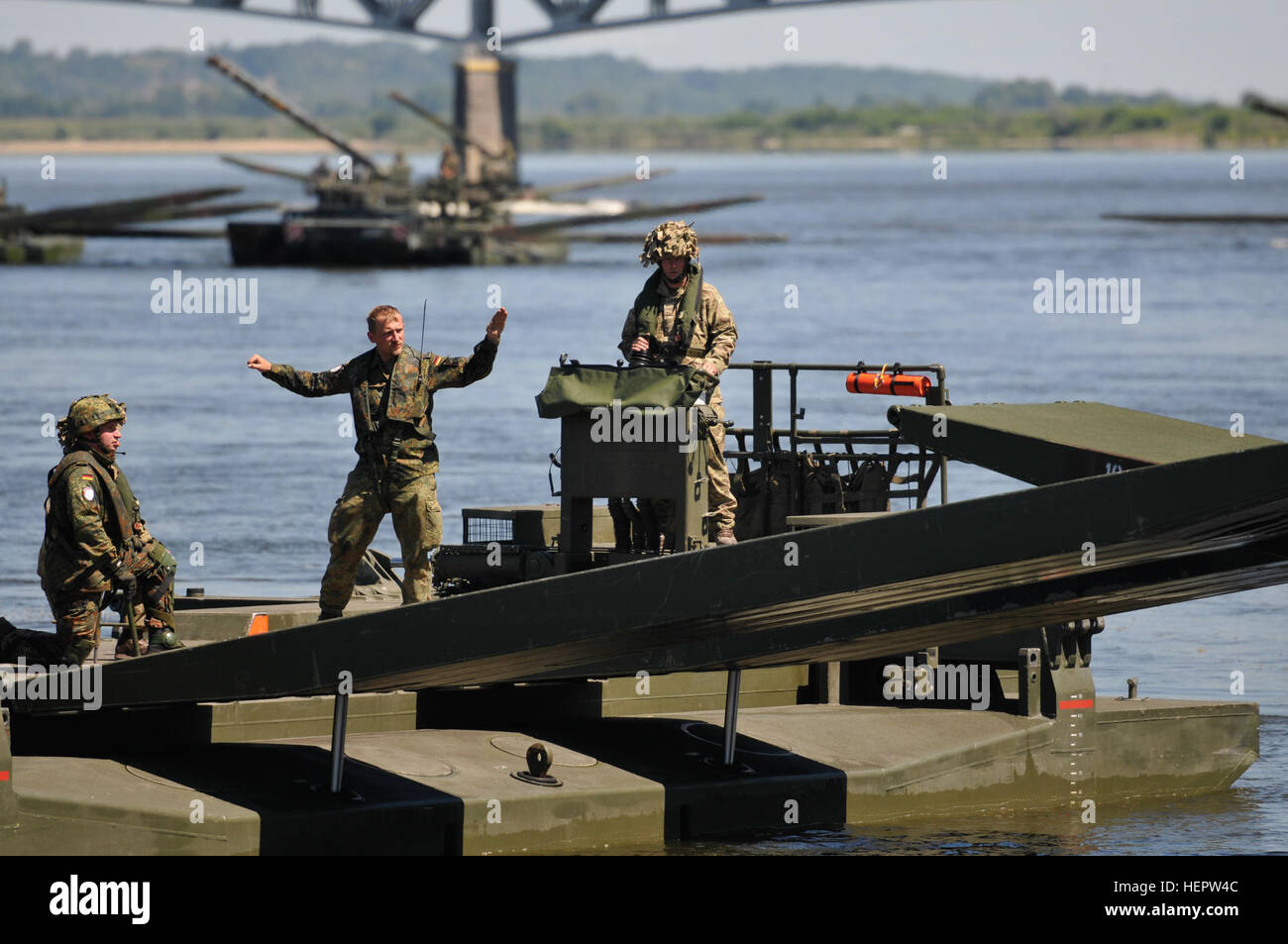 U.k. Amphibioius Rig Commander leitet in eine gemeinsame Brücke Kreuzung Demonstration sowohl in Deutschland als auch in U.K Soldaten die Heavy-Metal-Rampen aus einem Ampbibious Rig zum anderen sperren, um eine massive Brücke über einen prominenten Fluss in Chelmno, Polen 8 Juni während Anakonda 16 erstellen. Übung Anakonda 2016 ist ein Polnisch-led, multinationale führende Fortbildungsveranstaltung statt in ganz Polen 7-17. Juni. In der Übung sollen mehr als 25.000 Teilnehmer aus mehr als 20 Nationen. Anakonda-16 ist eine führende Fortbildungsveranstaltung für US-Army in Europa und teilnehmenden Nationen und zeigt die Vereinigten Stockfoto